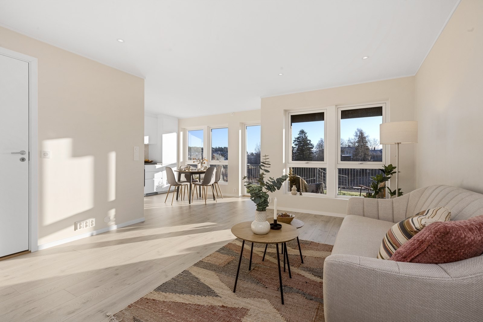 Romslig stue/spisestue med åpen kjøkkenløsning har laminatgulv fra Pergo med vannbåren gulvvarme og malte gipsvegger. Malt gipstak med innfelte LED downlights med dimmer Galleribilde