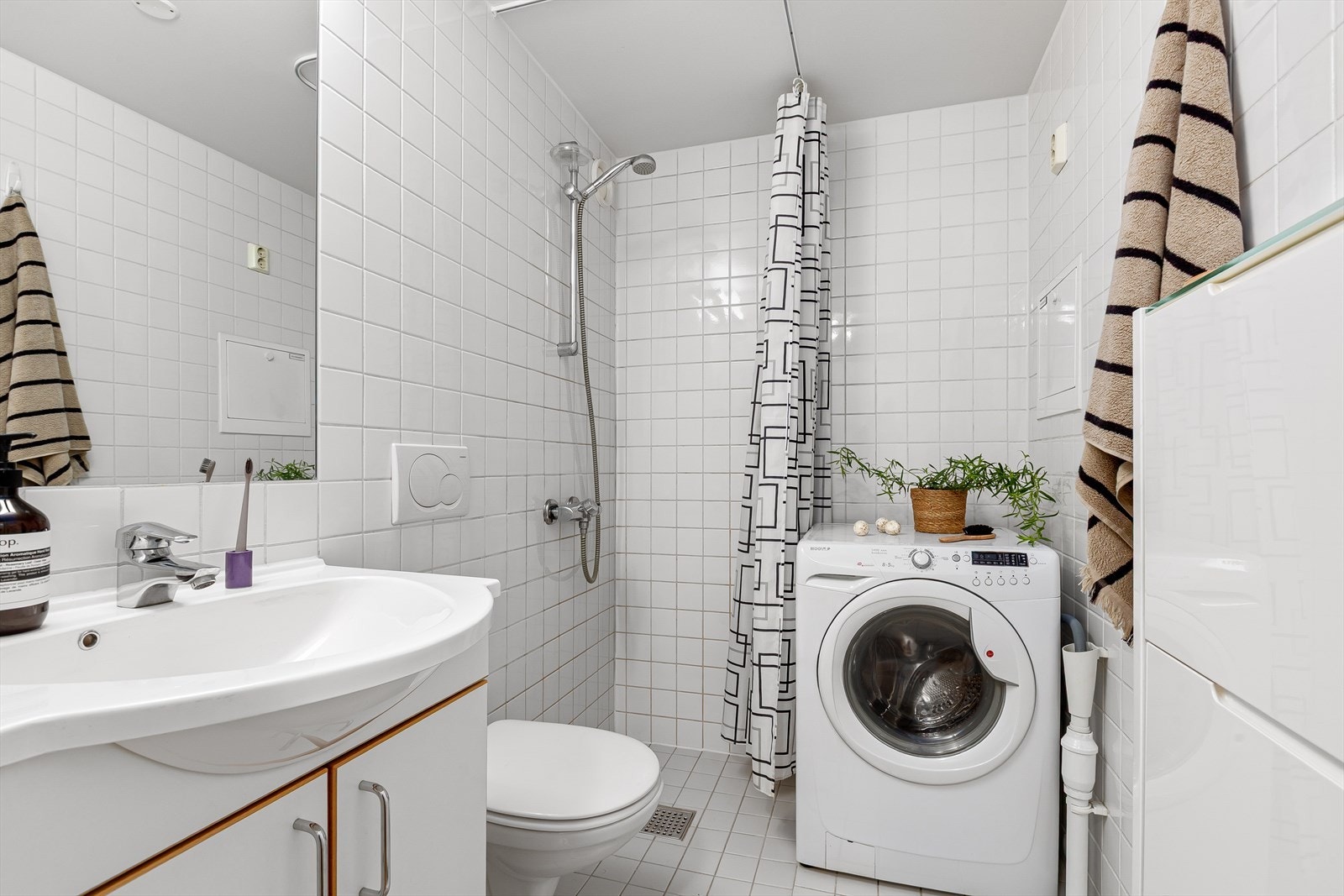 Helfliset baderom med varme i gulv og opplegg for vaskemaskin Galleribilde