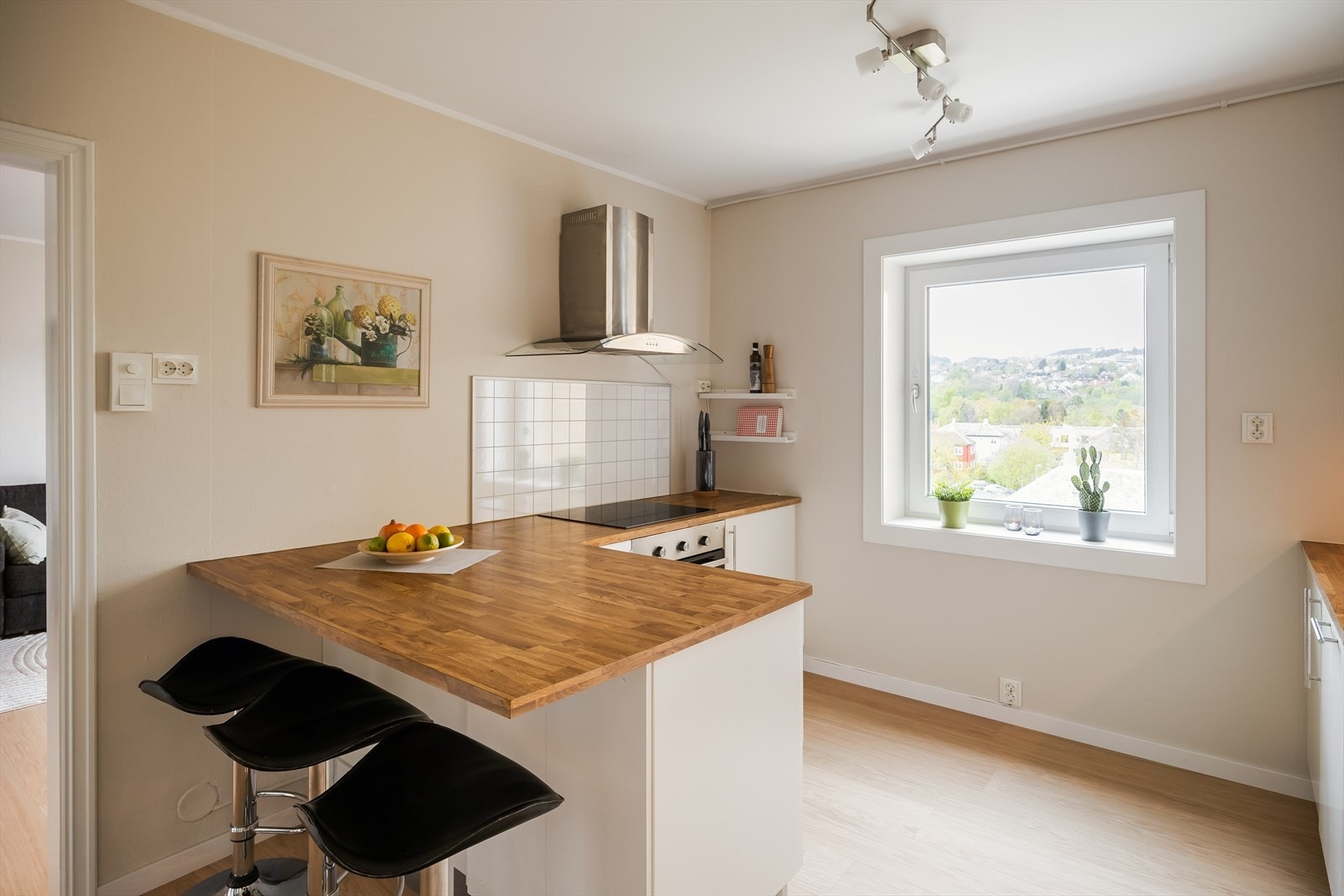 Kjøkkenet har en praktisk barløsning som gir ekstra skap- og benkeplass. Galleribilde