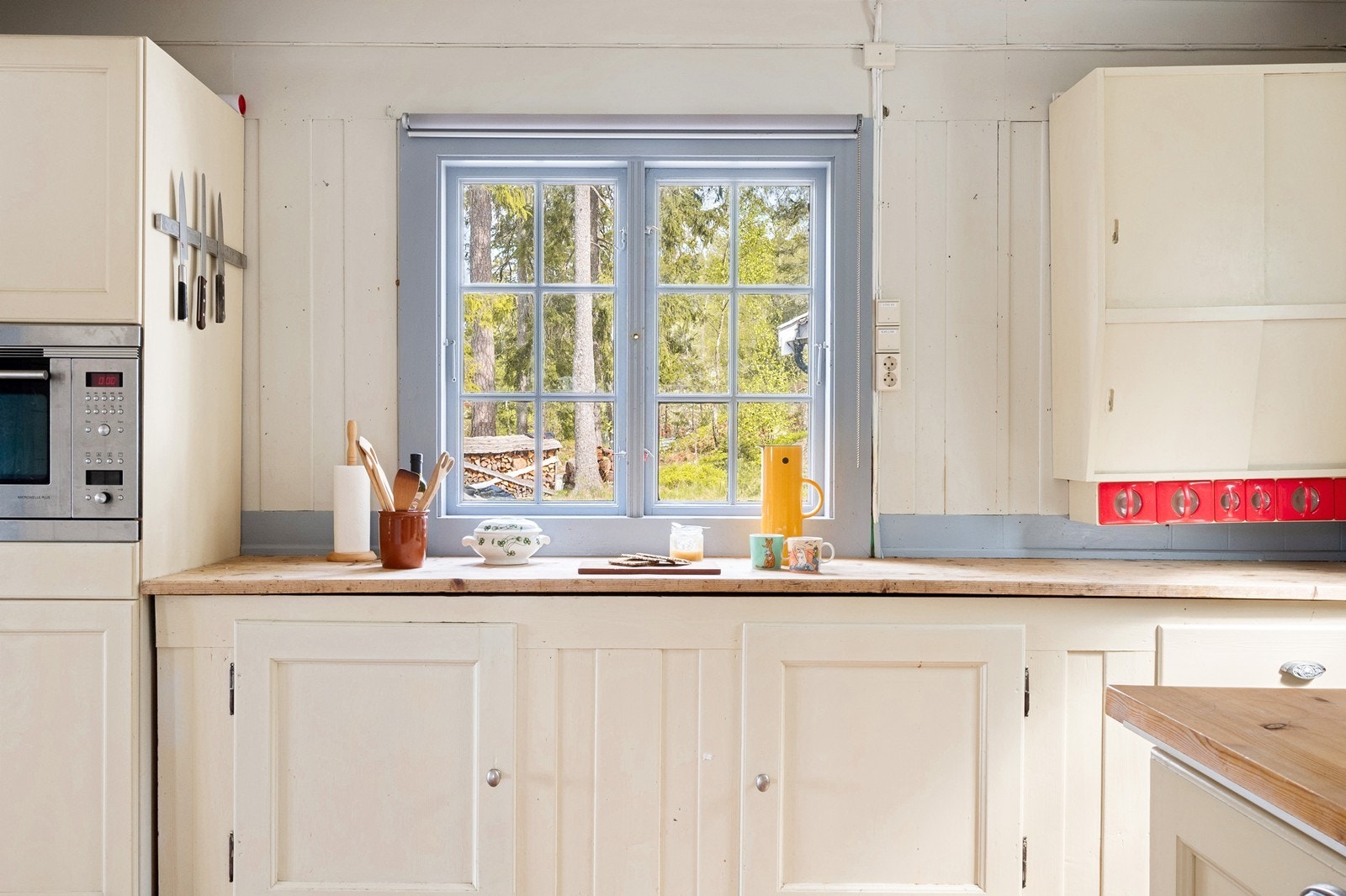 Både innredning og benkeplate er i heltre, der frontene er malte og supplert med overskap med skyvedører. Galleribilde