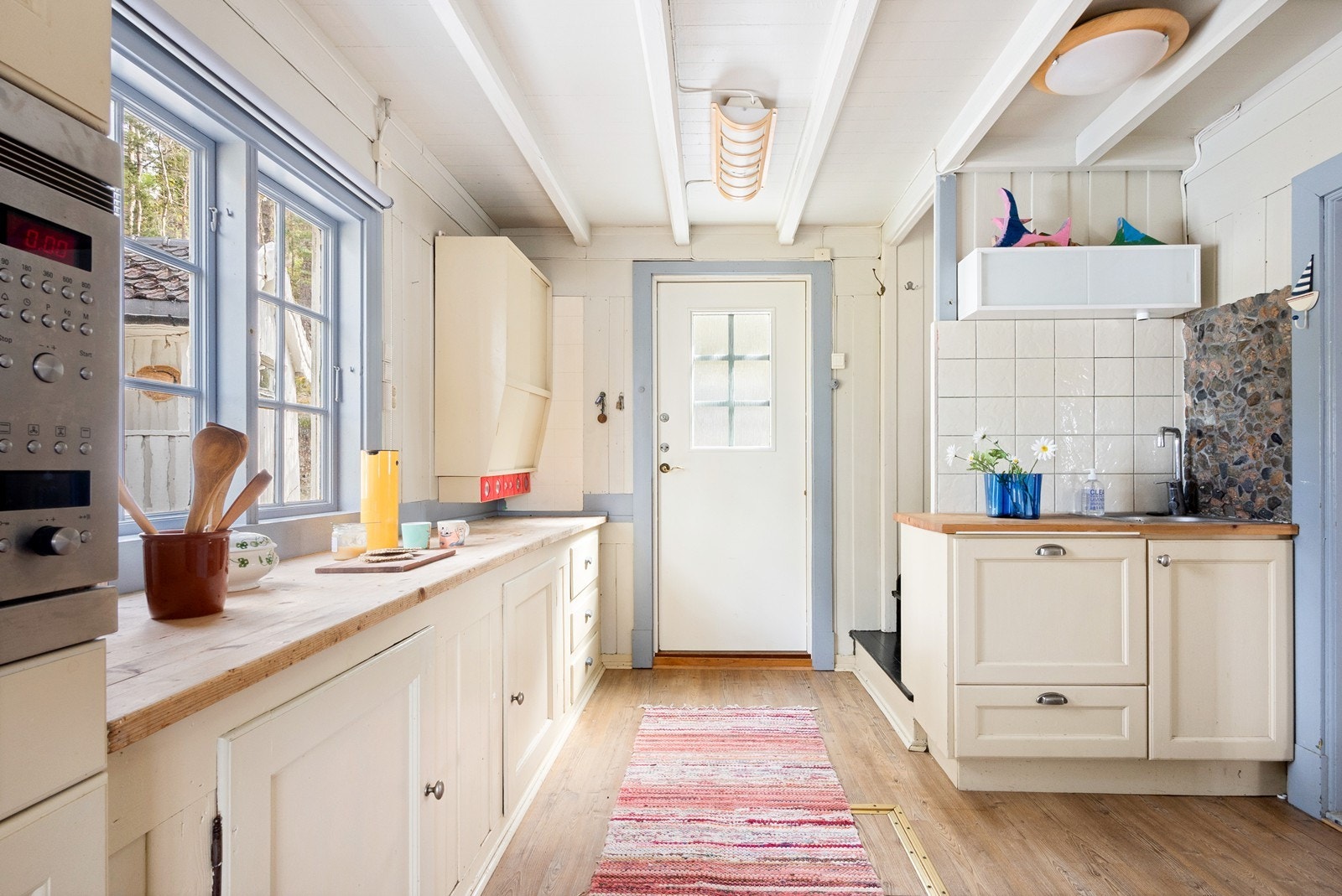 Innenfor døren er det trapp til 2. etasje og et sjarmerende, lyst og åpent kjøkkenrom. Galleribilde