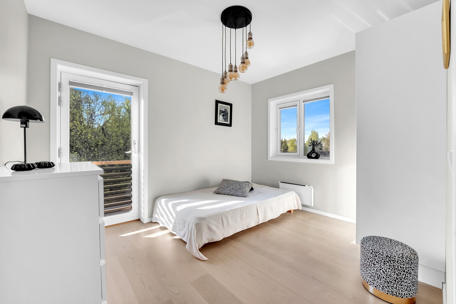 Boligens andre soverom er et sjarmerende rom med fransk balkong og behagelige fargetoner - perfekt for både små og store. Galleribilde