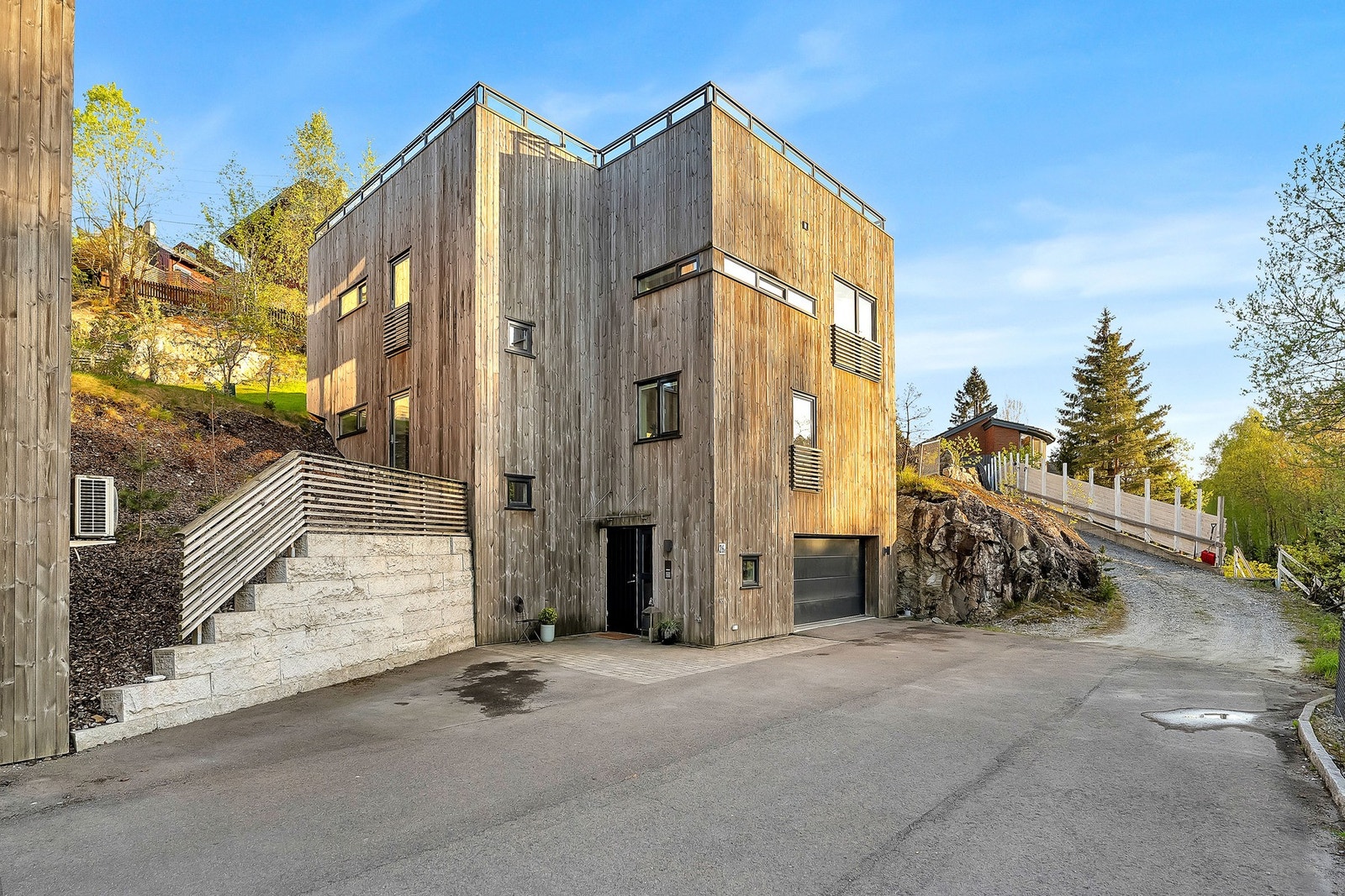 Fasaden fremstår like moderne og innbydende i dagslys - et helhetlig hjem for hele familien. Galleribilde