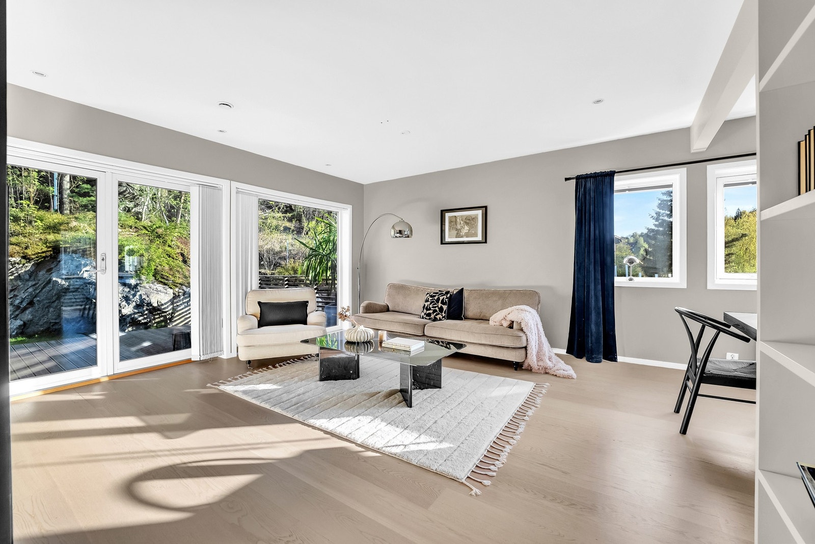 Lys og åpen stue med moderne peis, store vindusflater og elegant interiør - perfekt for hygge og samvær. Galleribilde