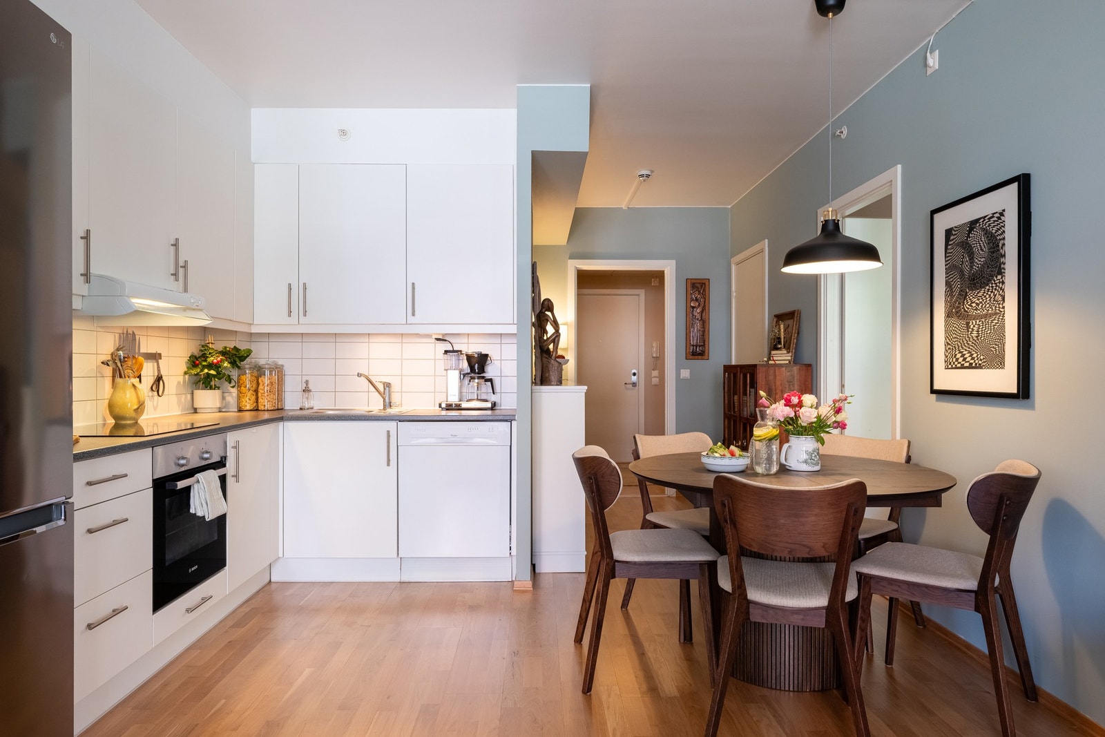 Lyst kjøkkenhjørne med glatte fronter, laminat benkeplate og nedfelt oppvaskkum med ett-greps blandebatteri. Galleribilde