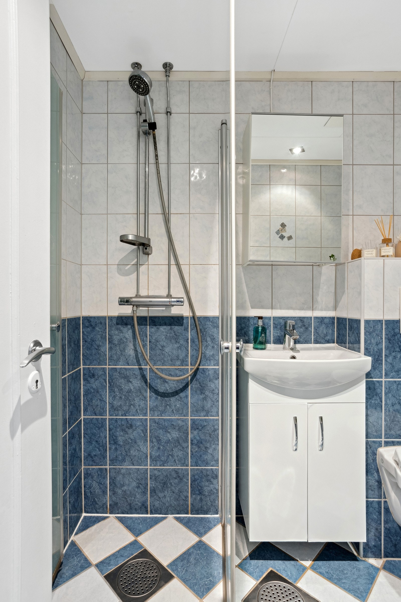Flislagt bad med gulvvarme og downlights, servant med servantskap under og dusj med innfellbare dusjvegger. Galleribilde