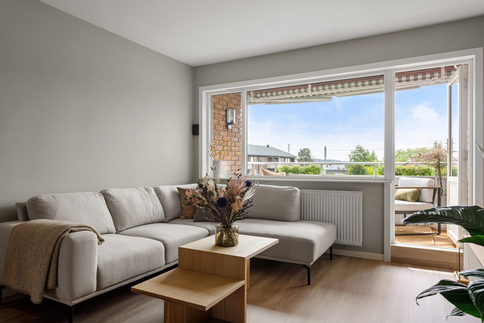 Boligens oppholdsrom er holdt i lyse fargevalg og har pent laminatgulv - noe som er gjennomgående for hele leiligheten. Galleribilde
