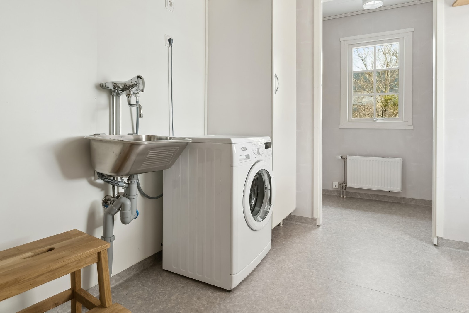 Vaskerom med vinylbelegg på gulv, veggene har baderomsplater i våtsone bak utslagsvask. Galleribilde