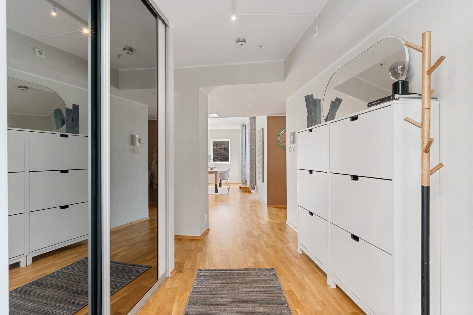 Velkommen inn i en hyggelig og romslig entre/gang med oppbevaringsmuligheter i speilgarderobe Galleribilde