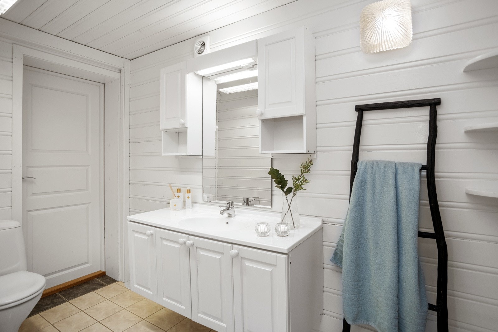 Baderom med flislagt gulv og varmekabler. Badet har innredning, toalett, dusj og badstue. Galleribilde