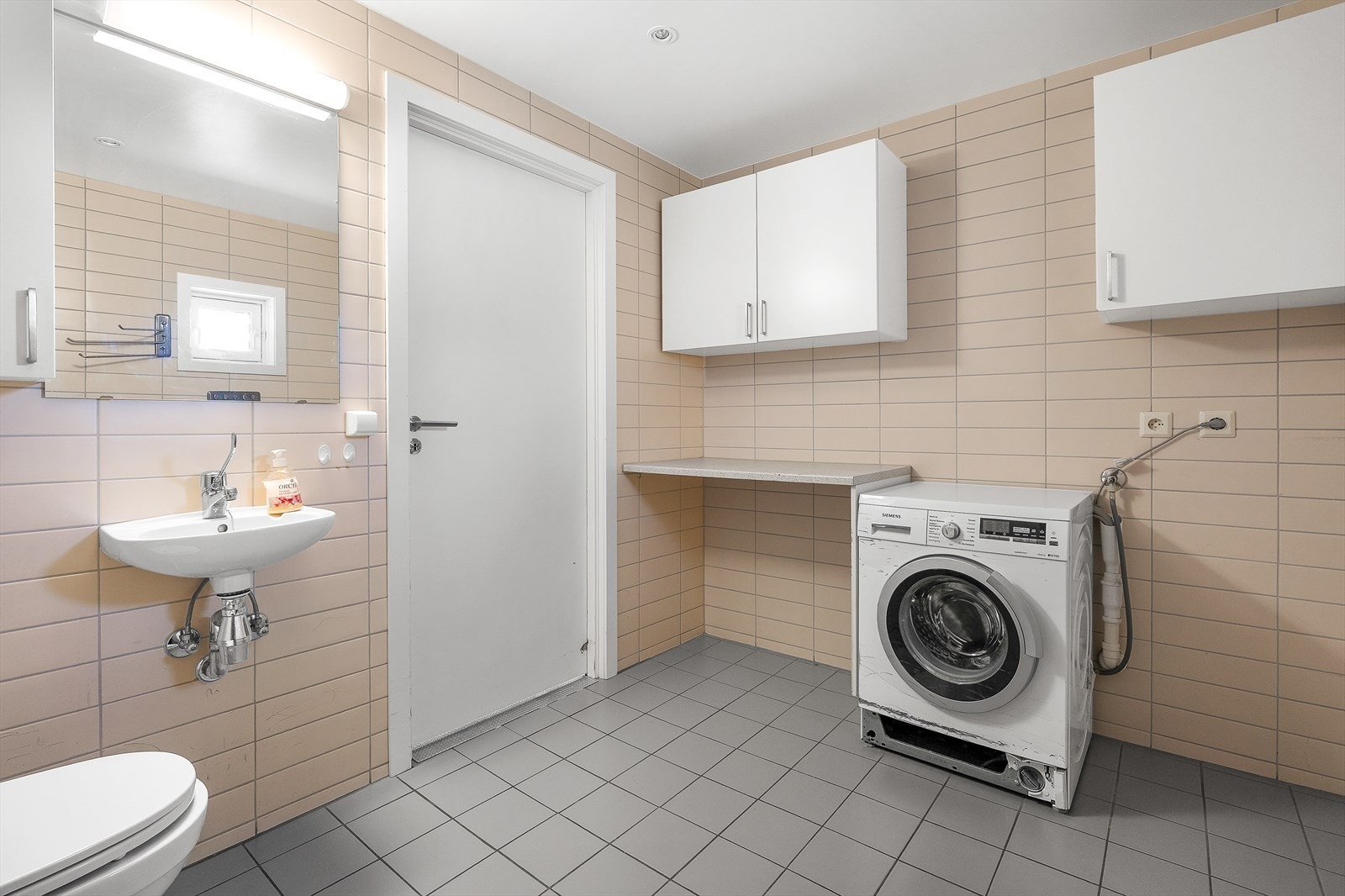 Flislagt bad med malt tak og opplegg for vaskemaskin. Galleribilde