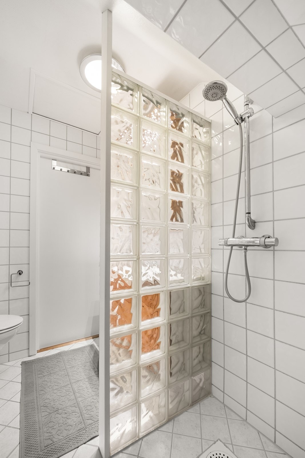 Badet har dusjnisje med dusjvegg av glassbyggerstein og veggmontert dusjarmatur - Rom er opprinnelig byggemeldt som uinnredet loft Galleribilde