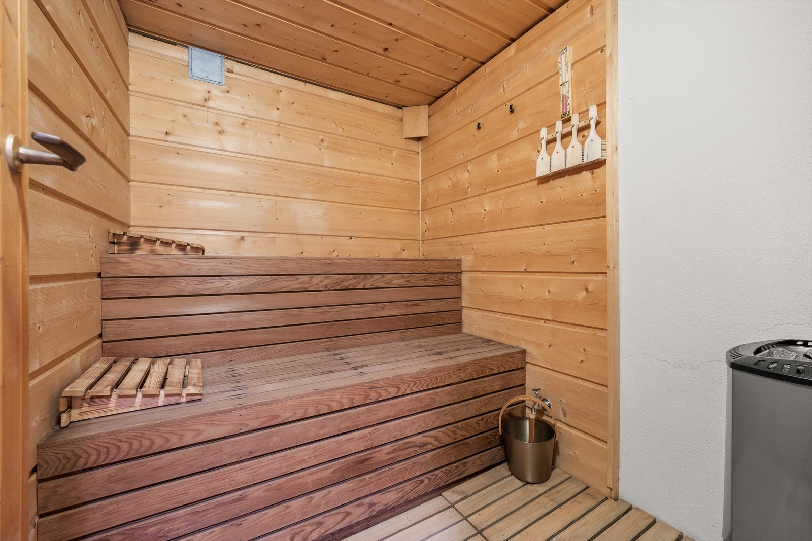Badstue med plassbygget sittebenker over to nivåer og nyere badstuovn Galleribilde