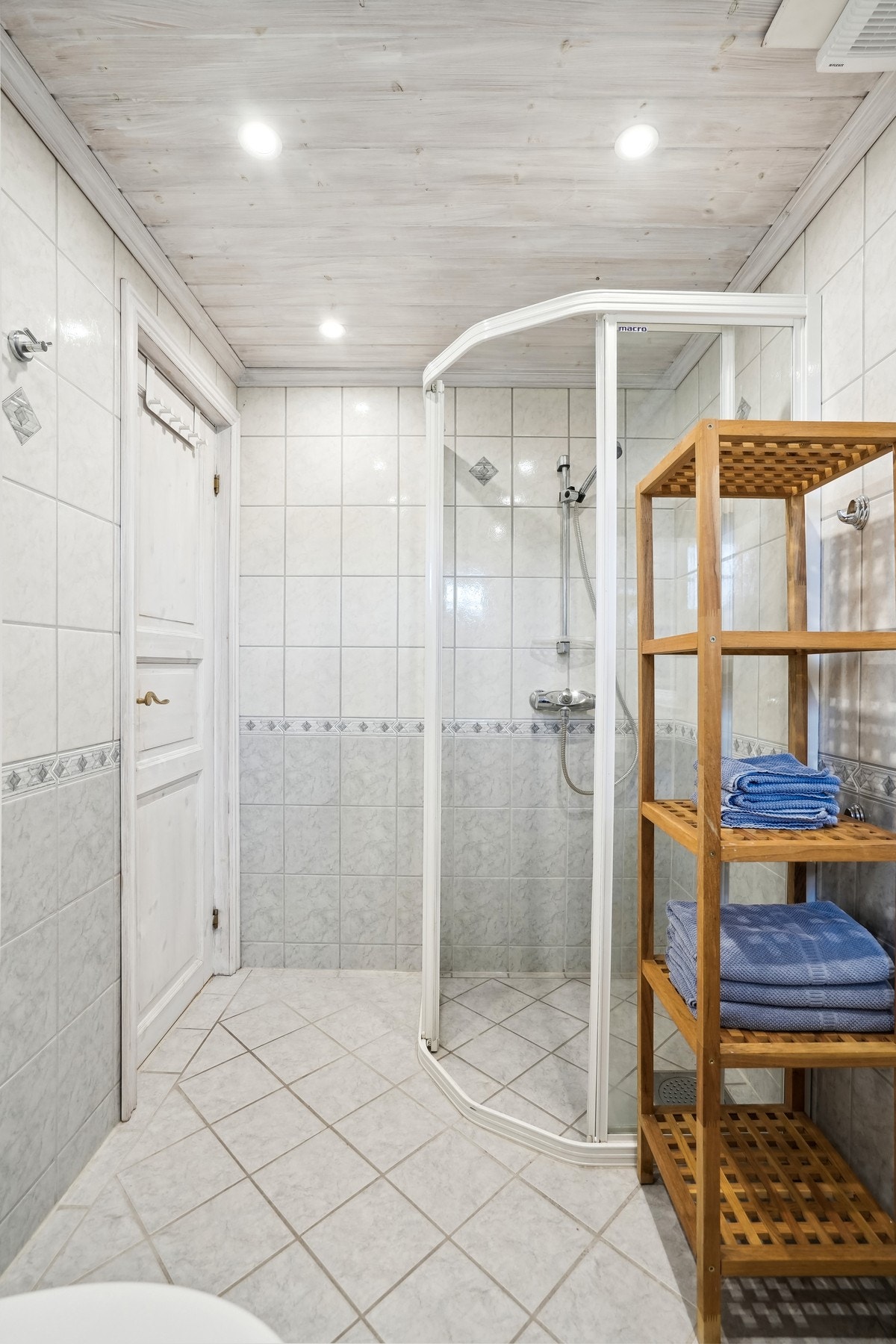 Badet er utstyrt med toalett, dusjhjørne og servant. Galleribilde