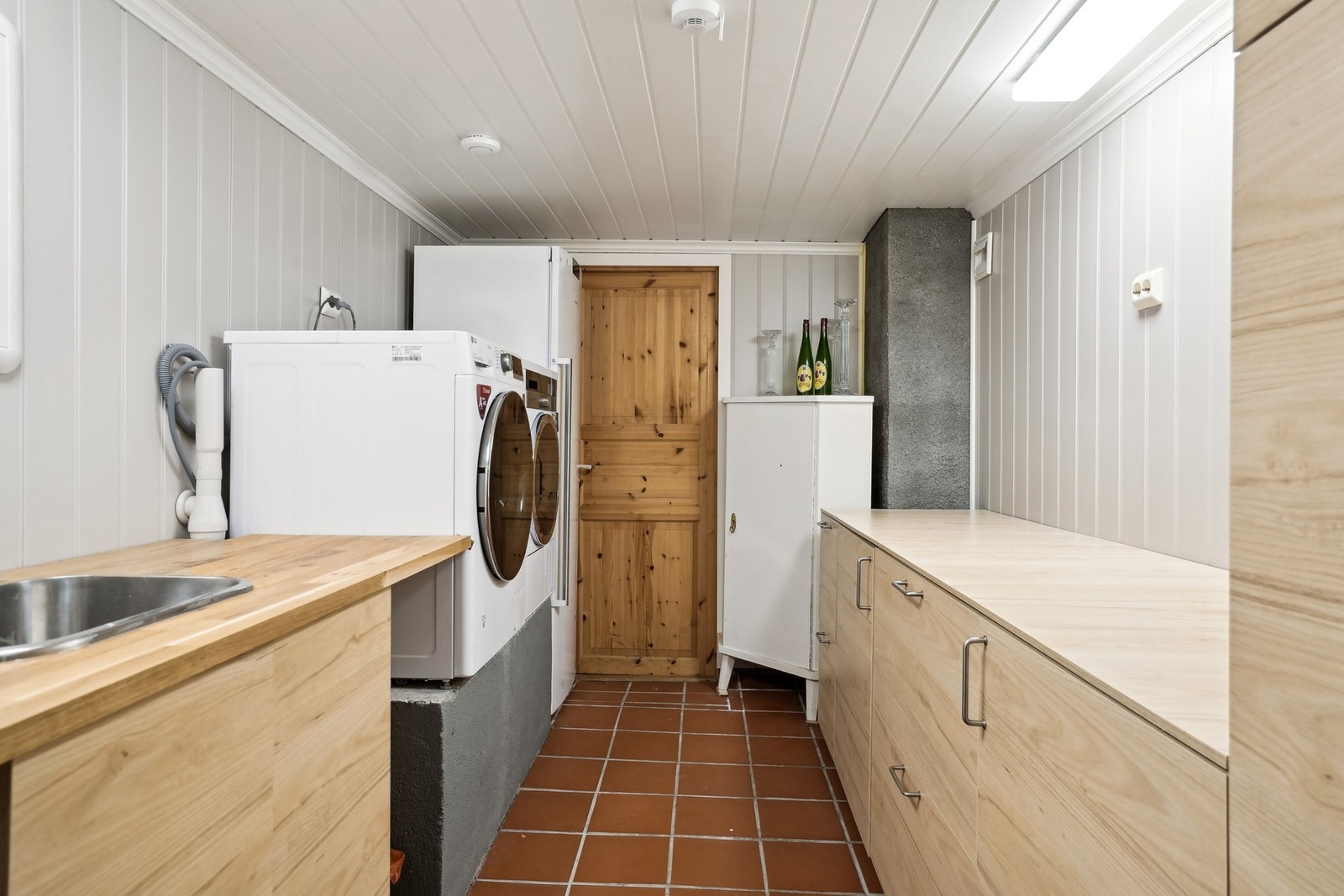 Praktisk vaskerom med innredning og opplegg for vaskemaskin og tørketrommel. Tilkomst til lagringsplass i boder. Galleribilde