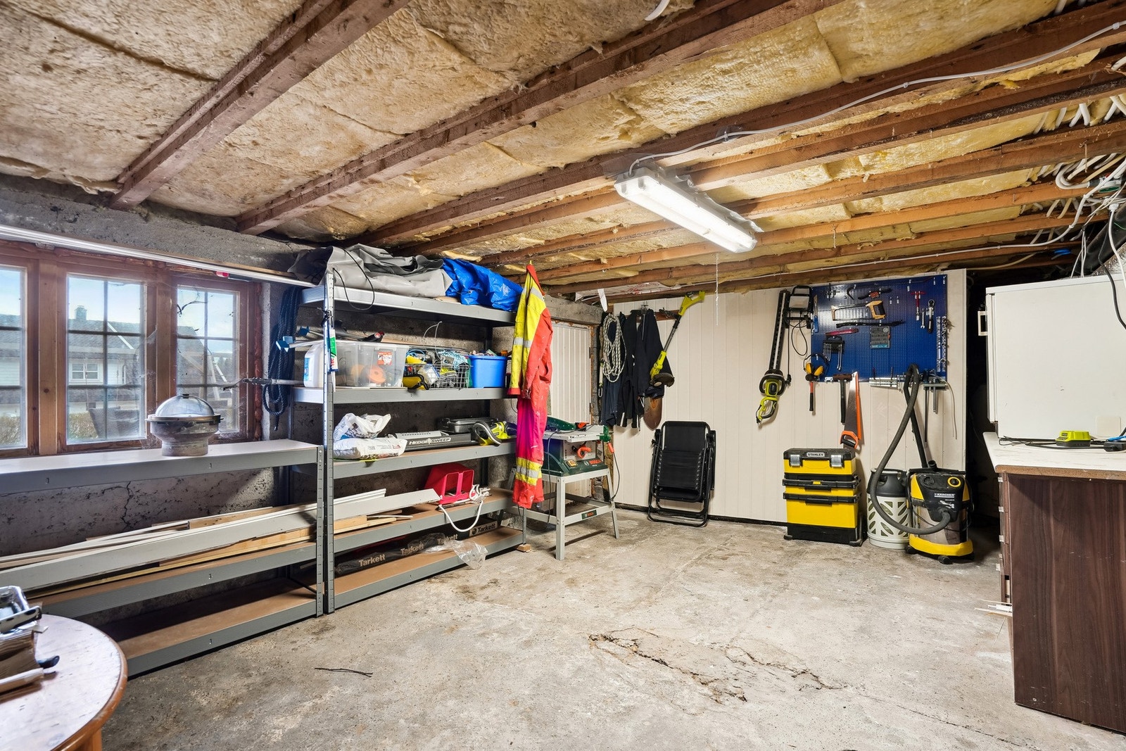 Stor bod med god lagringsplass. Dette rommet har også blitt benyttet som arbeidsrom. Utgang ut til terrasse og hagen på vestsiden av boligen. Galleribilde