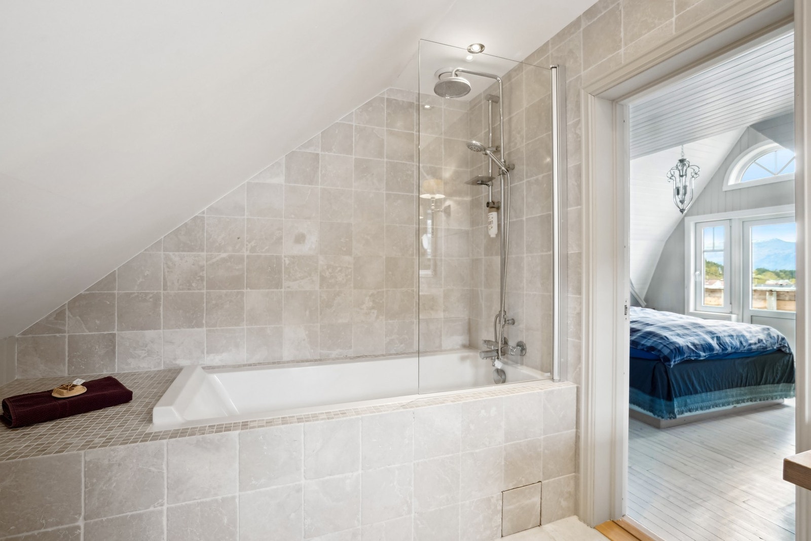 Badet er utstyrt med innfliset badekar med glass-skjerm og vegghengt toalett. Galleribilde