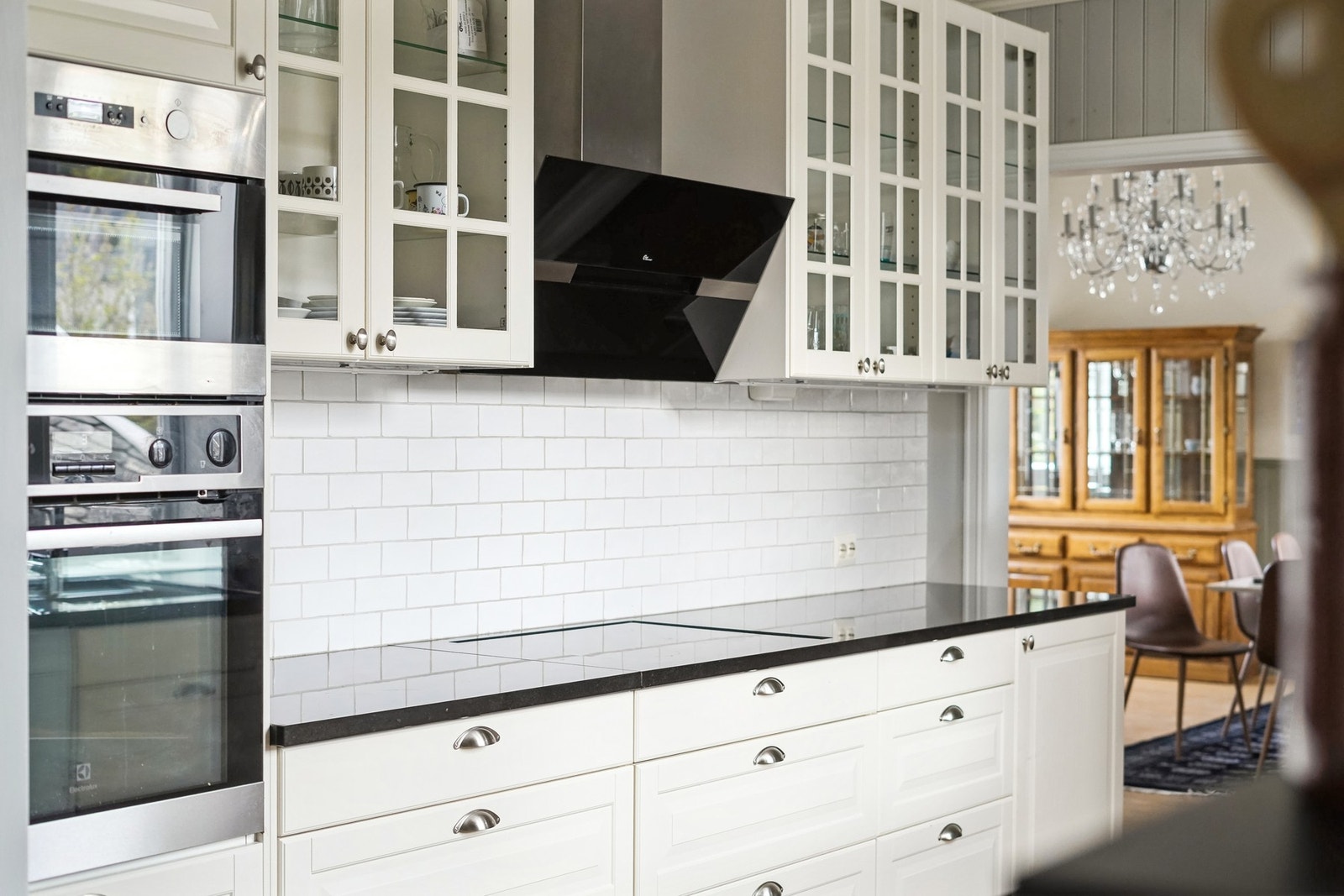 Flis på vegg over benkeplaten. Integrert induksjonsplatetopp, stekeovn (2015) og micro. Frittstående kjøleskap og oppvaskmaskin. Galleribilde