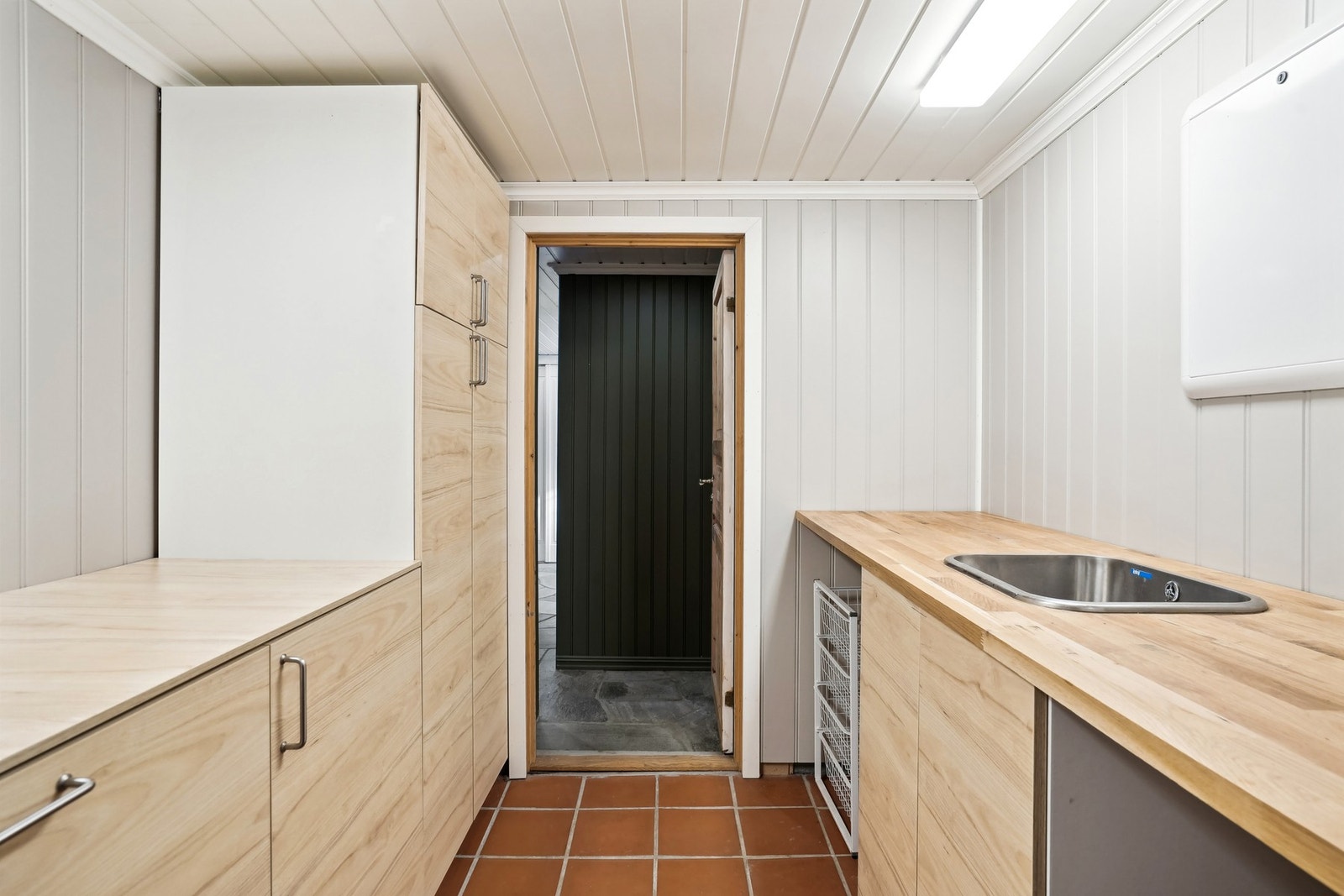 Vaskerom med klinkerflis på støpt gulv. Støpejernssluk. Mdf-panel vegger og himling. Galleribilde