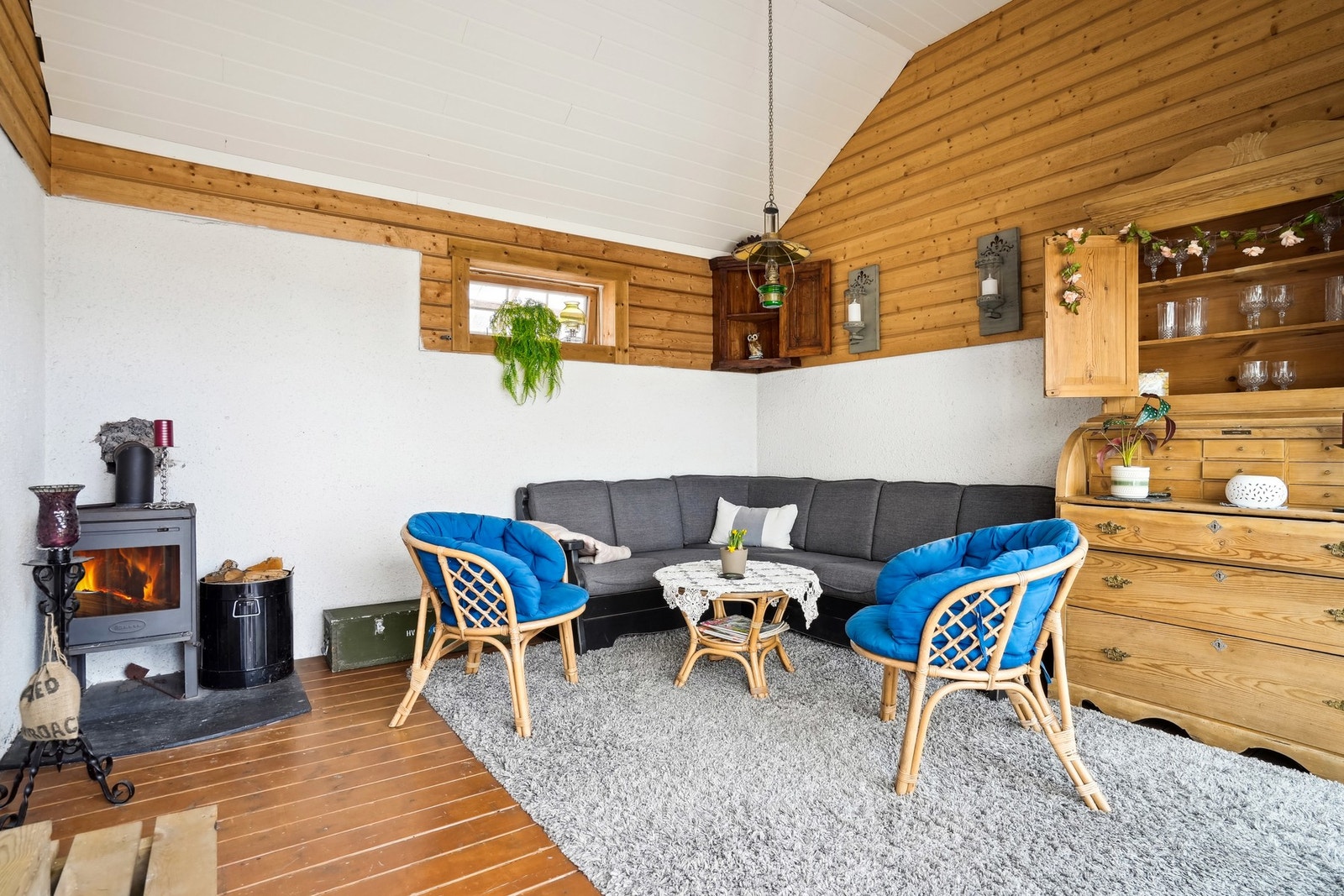 Det er terrassebord på gulvet og på veggene er det mur og panel. Galleribilde