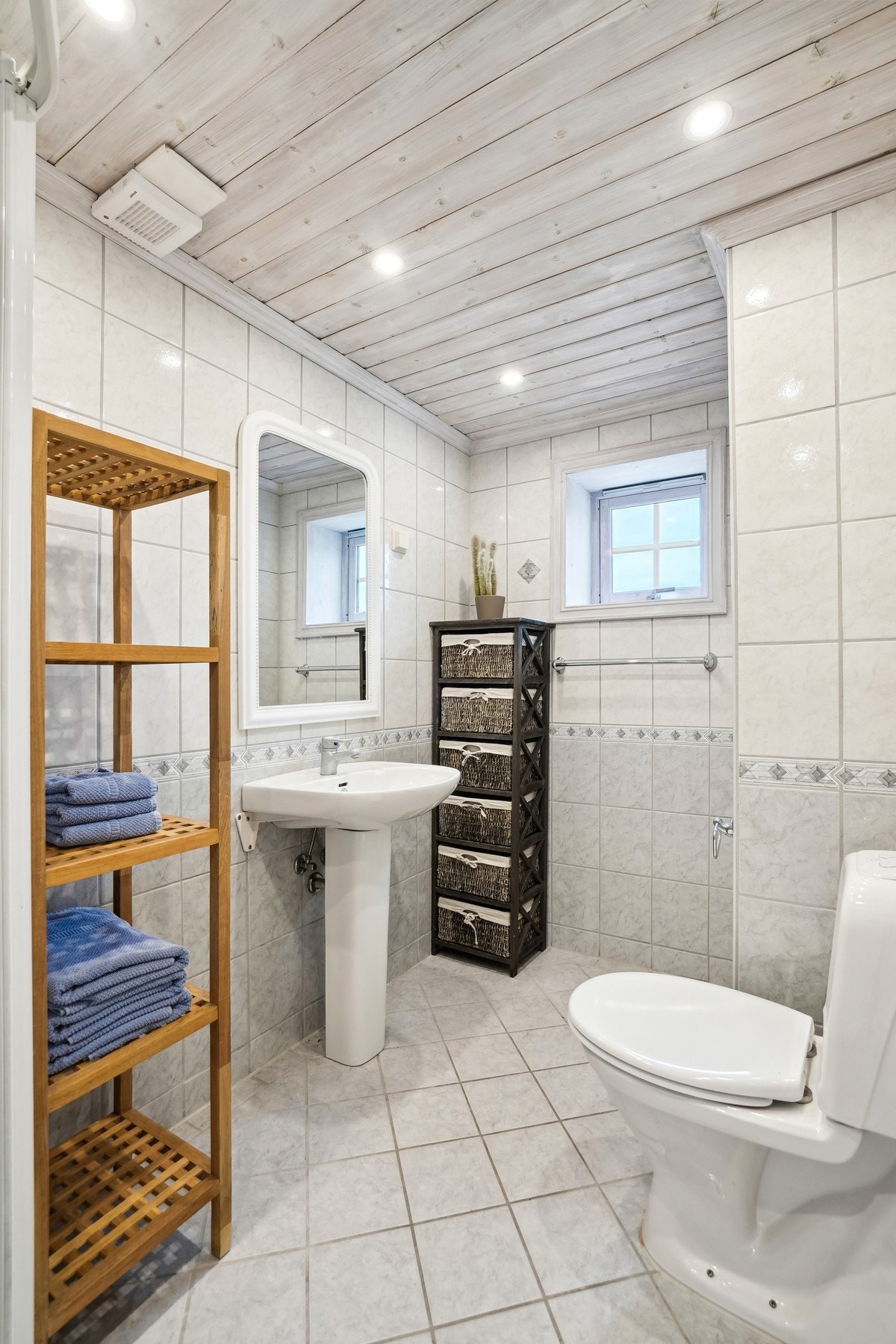 Bad er helfliset med elektriske varmekabler. Panelt himling med ledspotter. Oppusset i 2000. Galleribilde