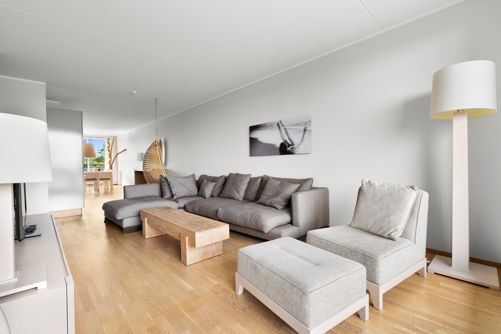 Lys og moderne stue med åpen løsning mot kjøkken og spisestue. Store vindusflater slipper inn naturlig lys og skaper en romslig atmosfære. Galleribilde