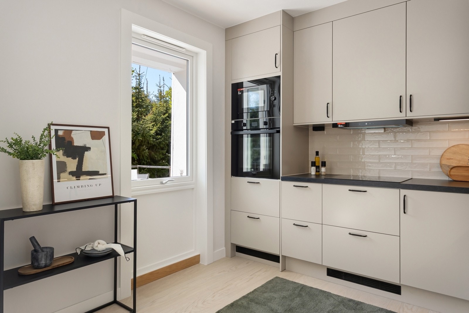 Kjøkkenet har integrerte hvitevarer inkludert oppvaskmaskin, stekeovn, platetopp og kjøl/frys, som bidrar til et helhetlig og sømløst design. Galleribilde