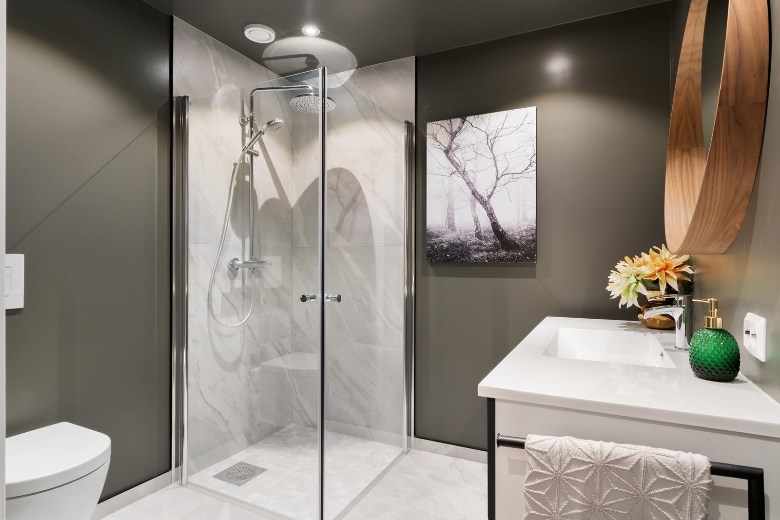 Badet i underetasje har dusjsone med marmor, vegghengt toalett og vask i servant Galleribilde