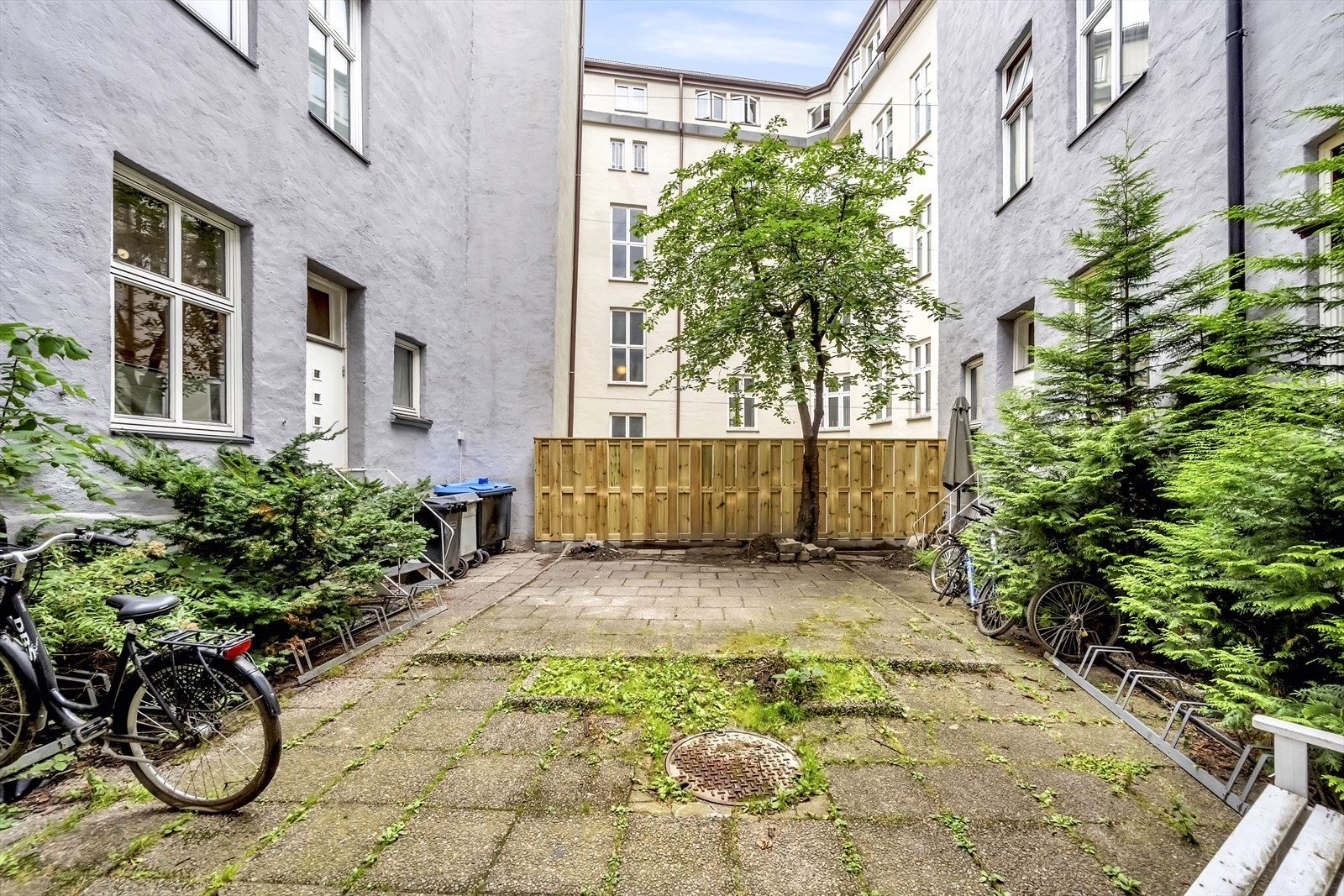 Lukket bakgård med sykkelparkering og beplantning. Galleribilde