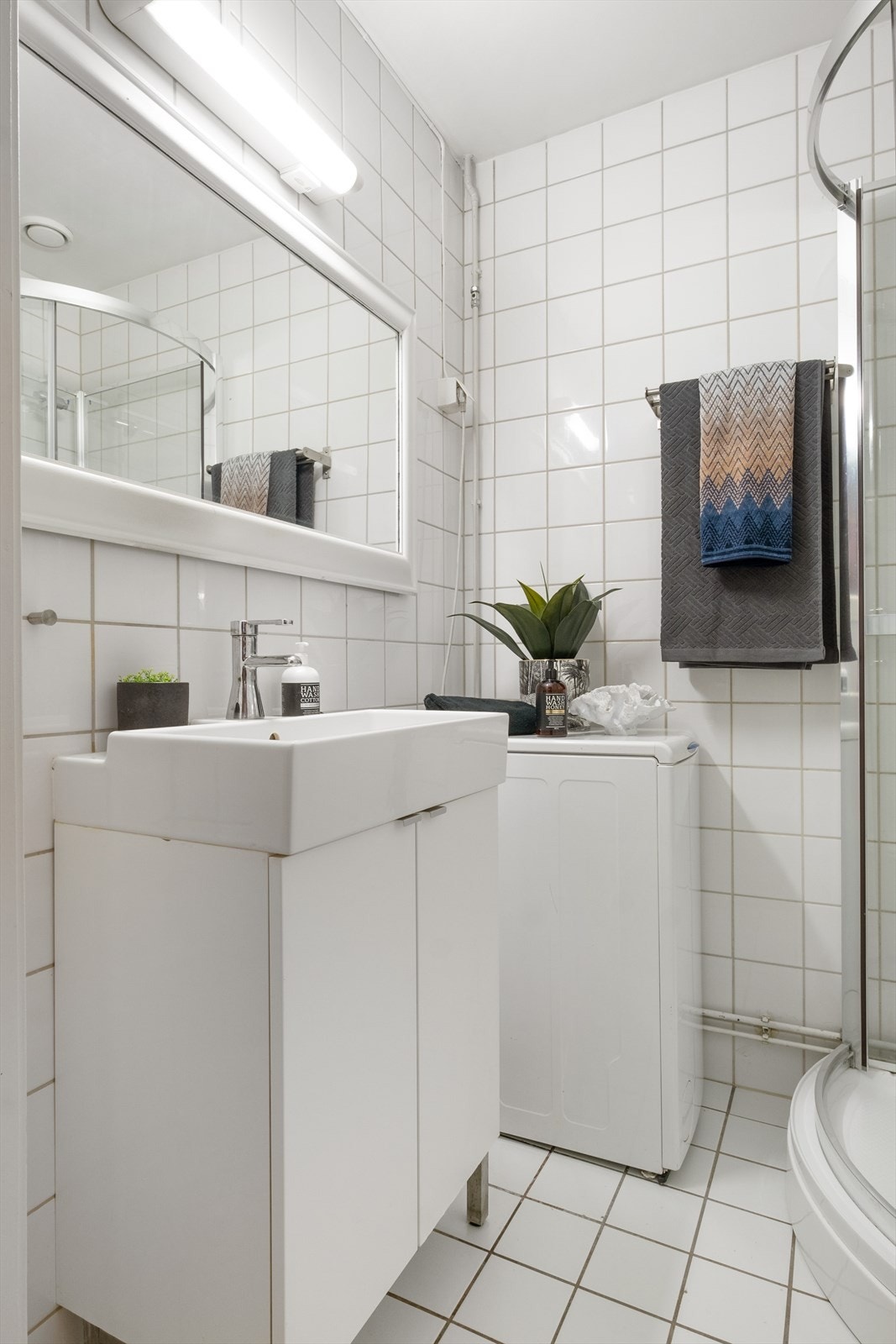 Badet er innredet med gulvmontert toalett, nytt dusjkabinett og servantinnredning med skap. Galleribilde