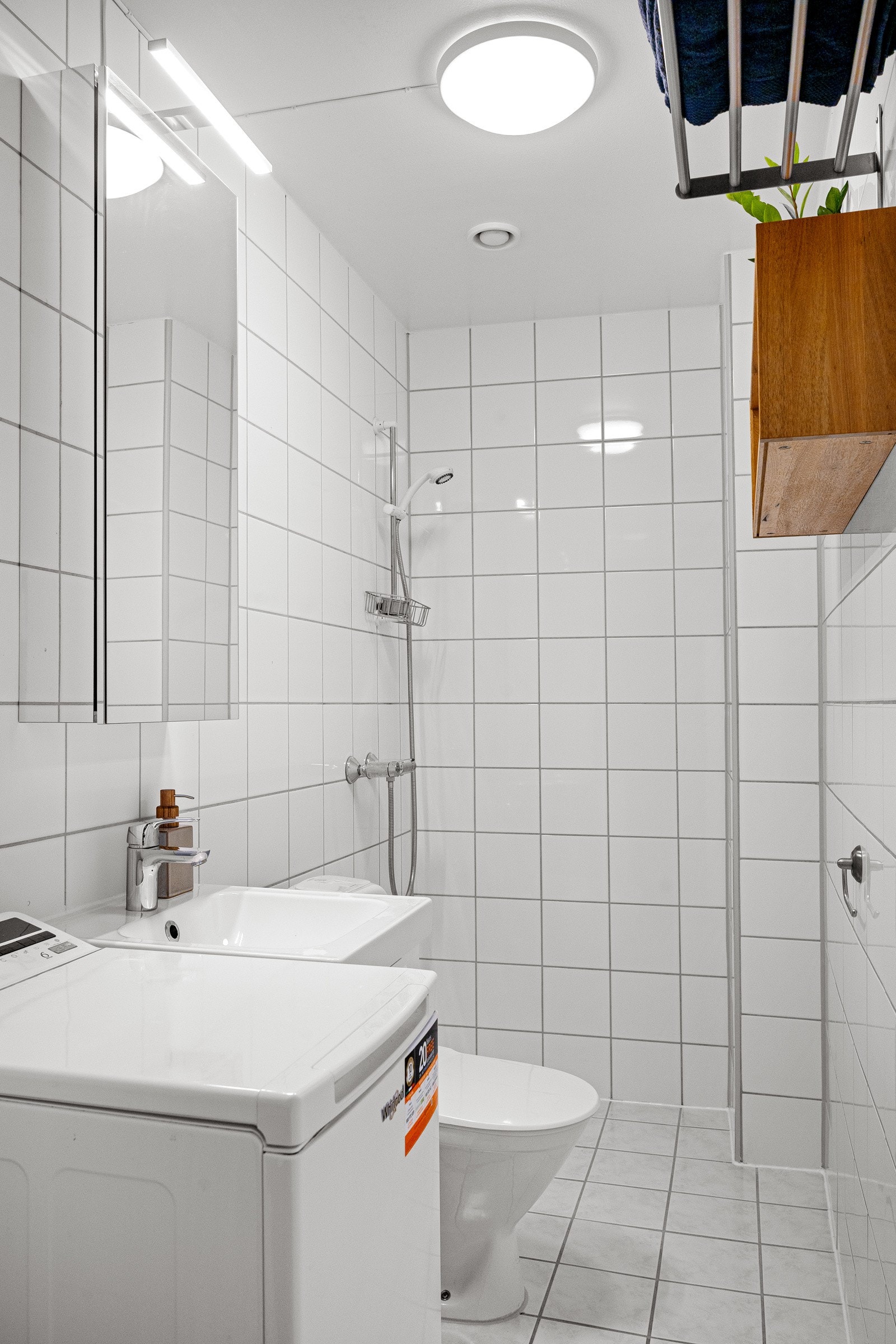 Eldre, flisalgt baderom fra med gulvvarme og opplegg for vaskemaskin. Galleribilde