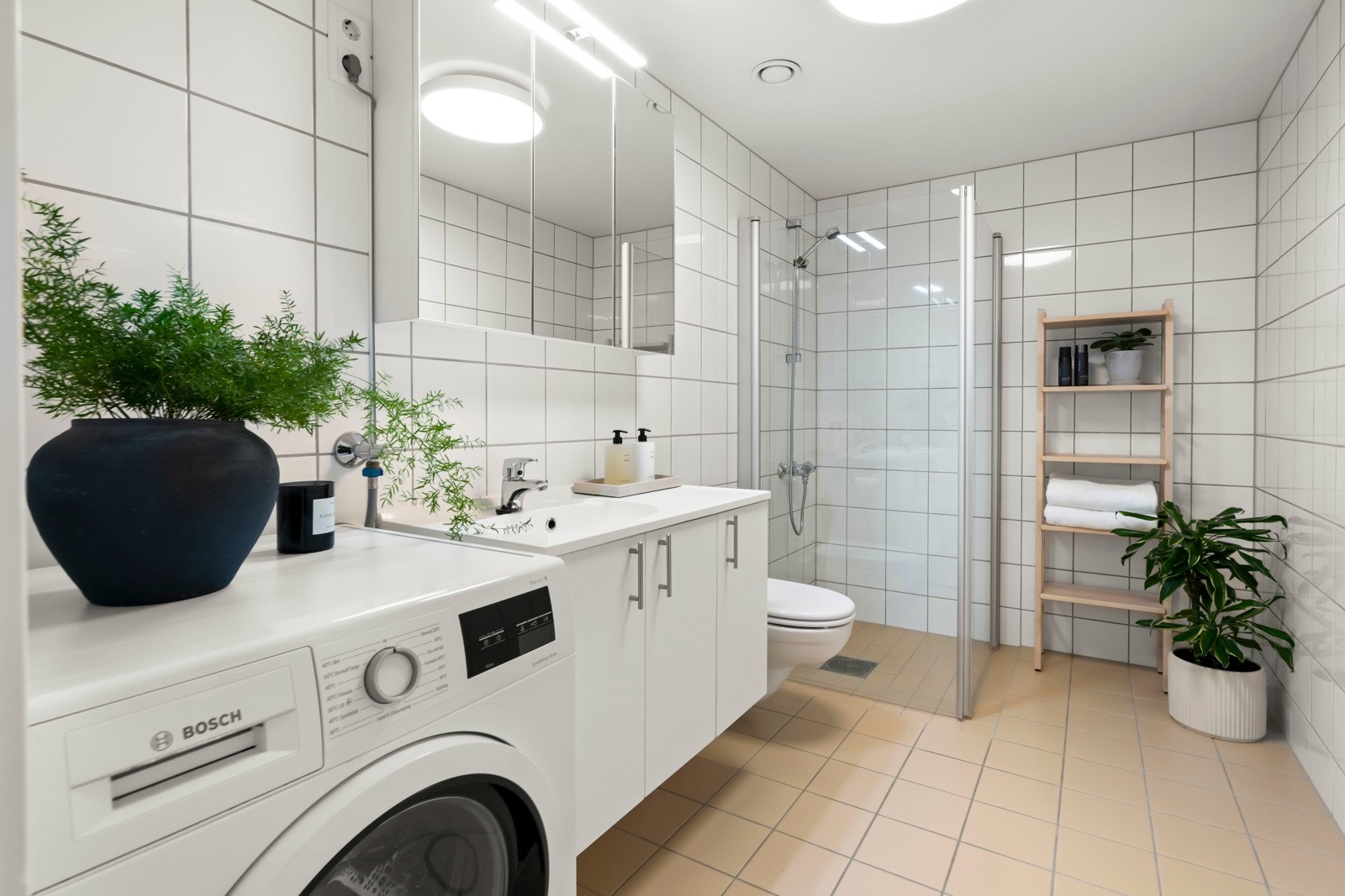 Delikat baderom fra byggeår med behagelig gulvvarme og opplegg for vaskemaskin og tørketrommel. Galleribilde