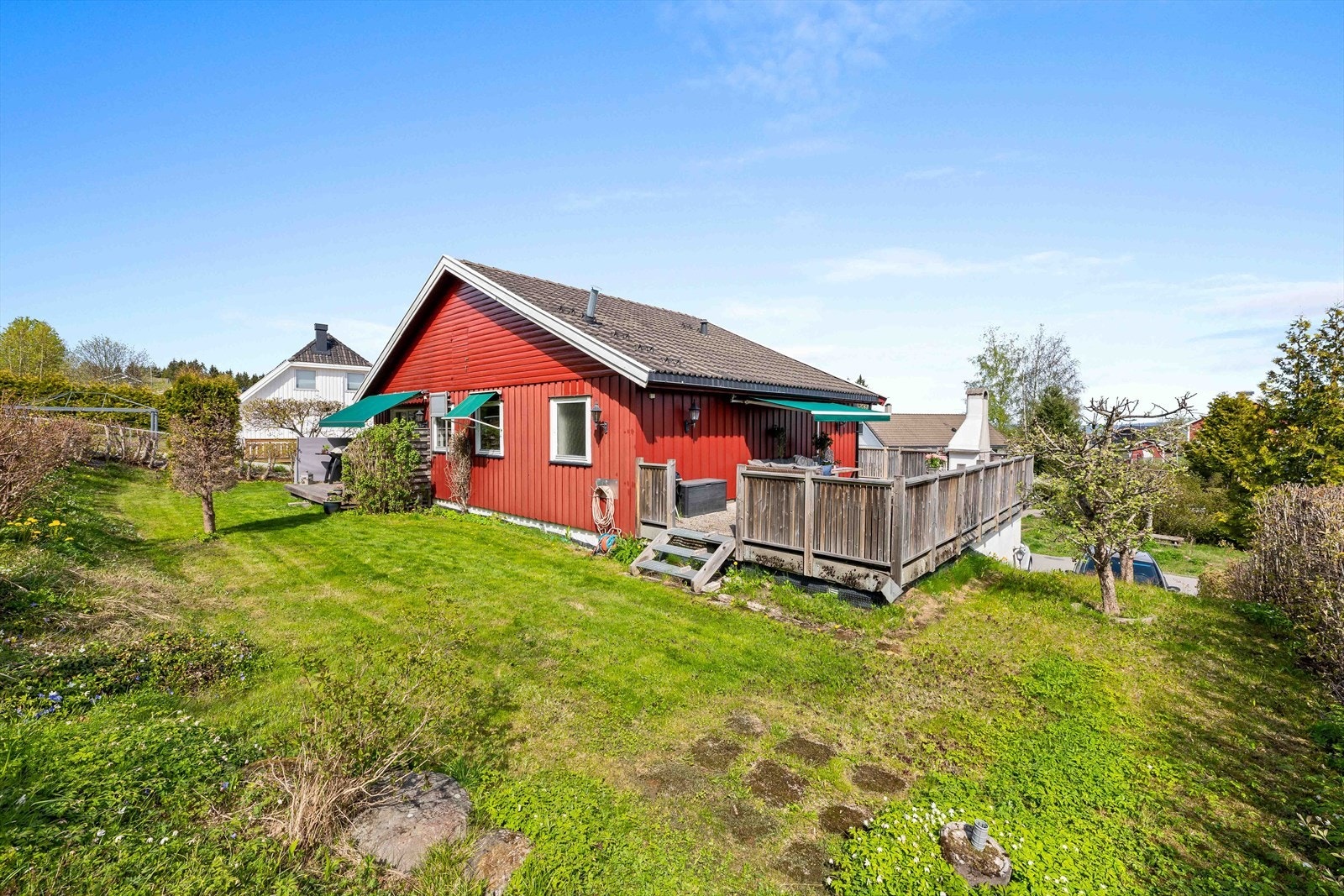 Koselig hage som er pent opparbeidet med gressplen, busker og diverse beplantning. Galleribilde