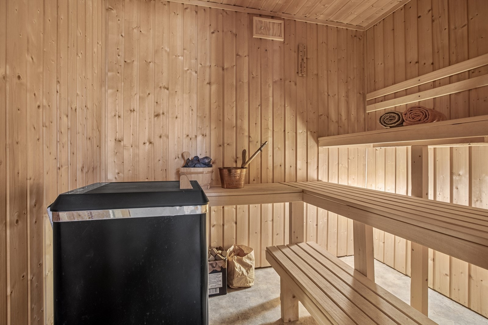Badstu med panel på veggene og belegg rett på betong på gulv. Galleribilde