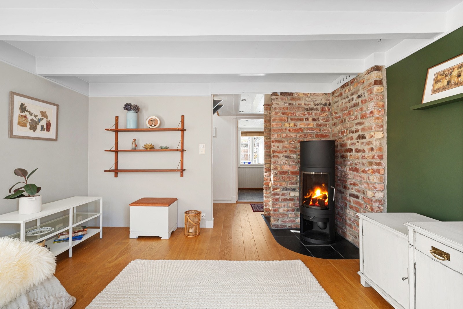 Boligen har bevart flere klassiske detaljer, slik som teglsteinsveggen i stuen og de synlige takbjelkene. Galleribilde
