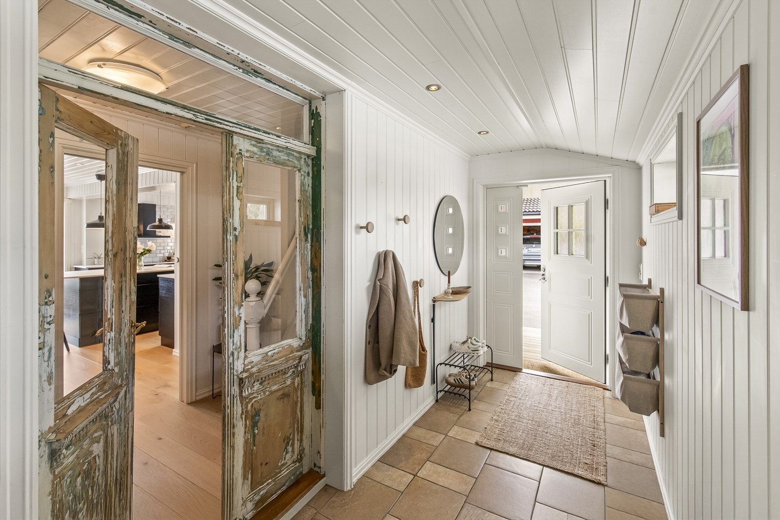 Flislagt og lys entré ønsker velkommen inn. Legg også merke til den vakre og dekorative dobbeltdøren mellom gangen og hoveddelen av huset. Galleribilde