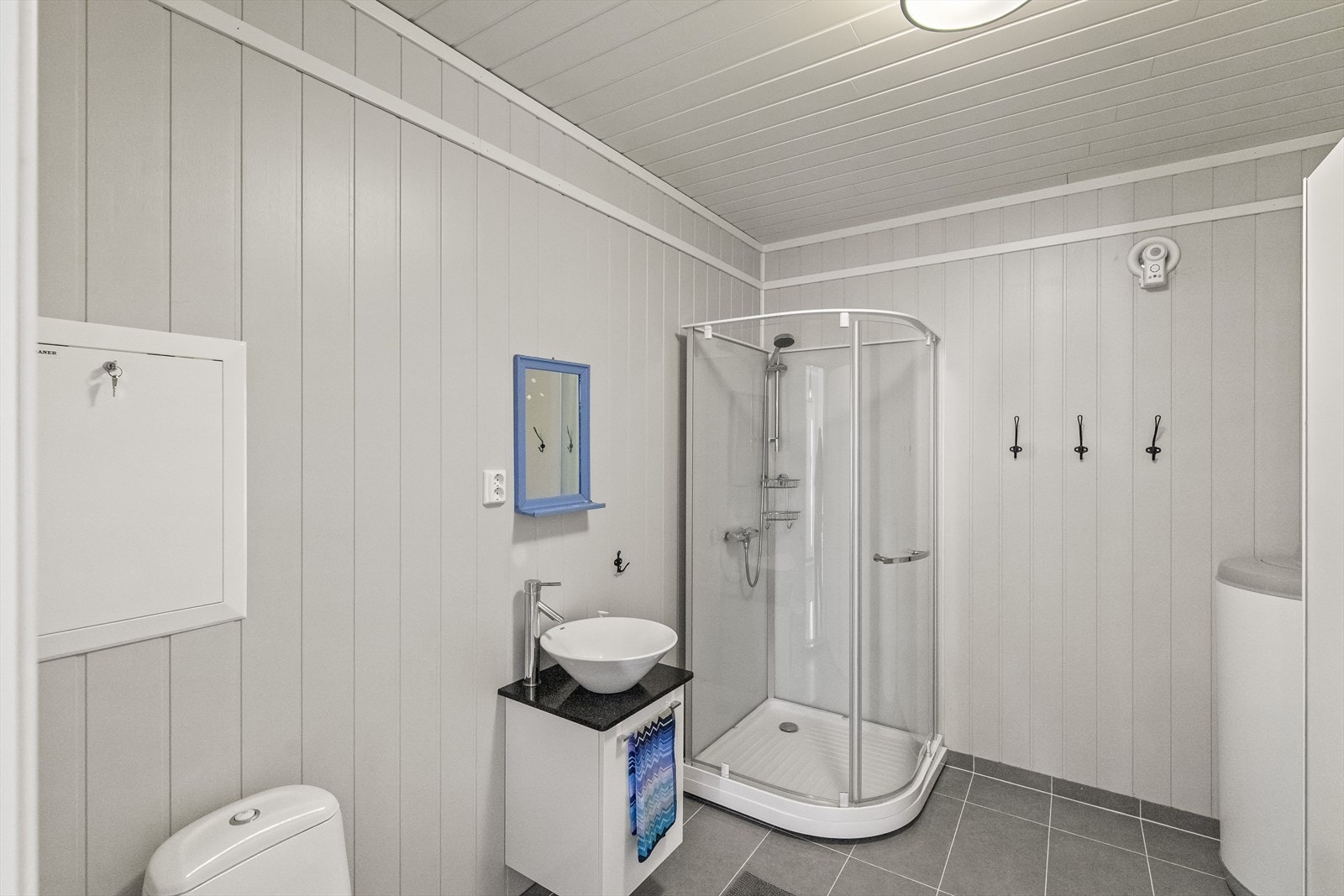 Badet er innredet med dusjkabinett, toalett og servant, og har flislagt gulv med varme. Galleribilde