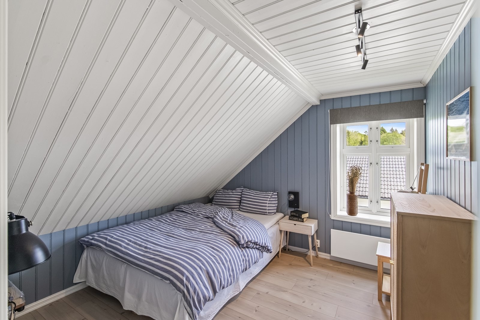 De øvrige tre soverommene er gjennomført innredet med smakfulle fargetoner, panelvegger og laminat i ett-stavs design. Galleribilde