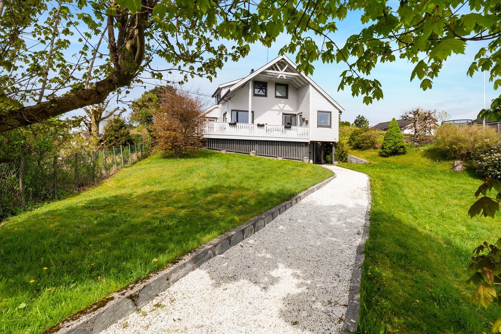 Pent opparbeidet hage med plener og beplantning. Fine murer i både naturstein og betong Galleribilde
