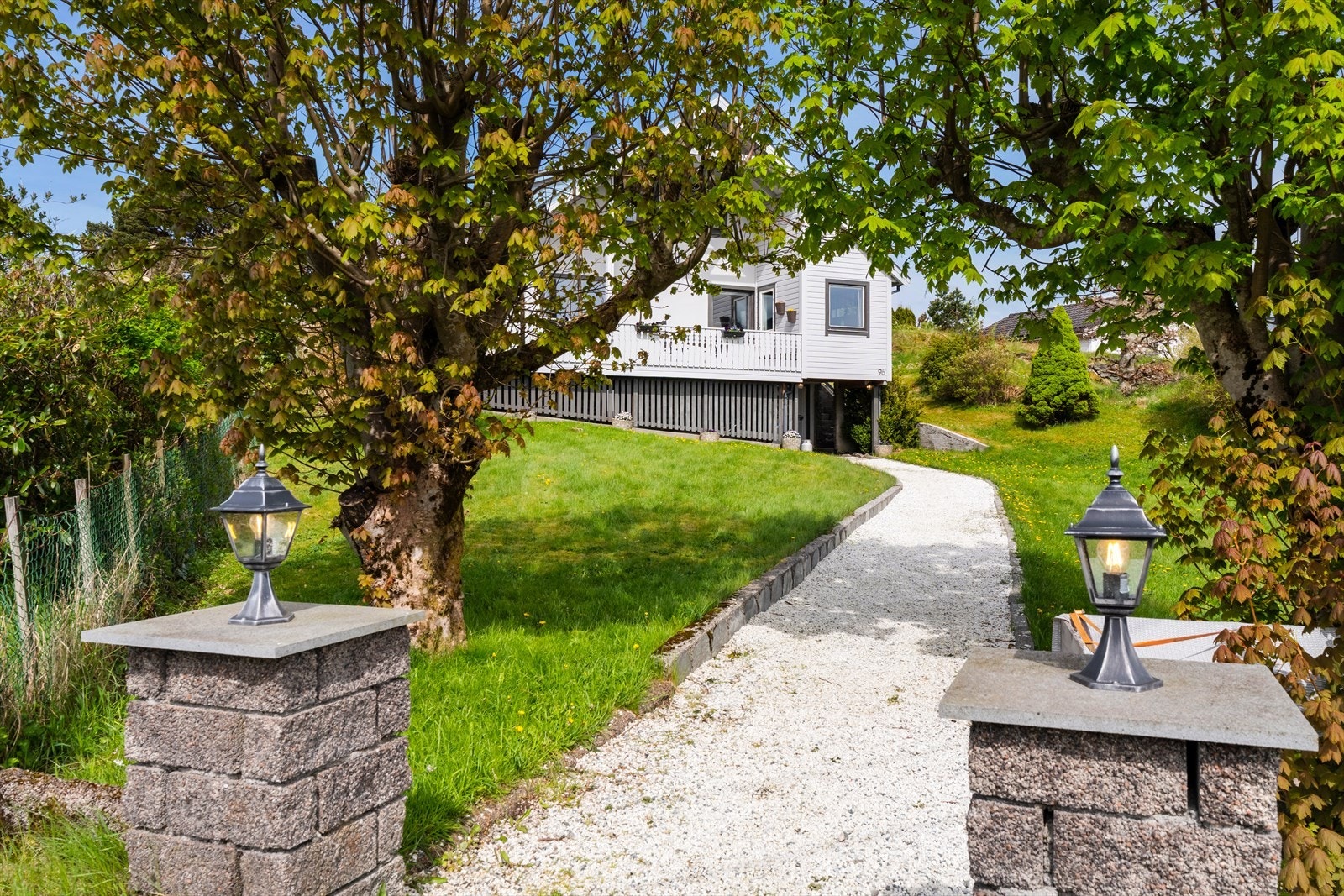 I tomtens grenser er det naturlig vegetasjon, og adkomsten opp til boligen går via en grussti midt på eiendommen Galleribilde