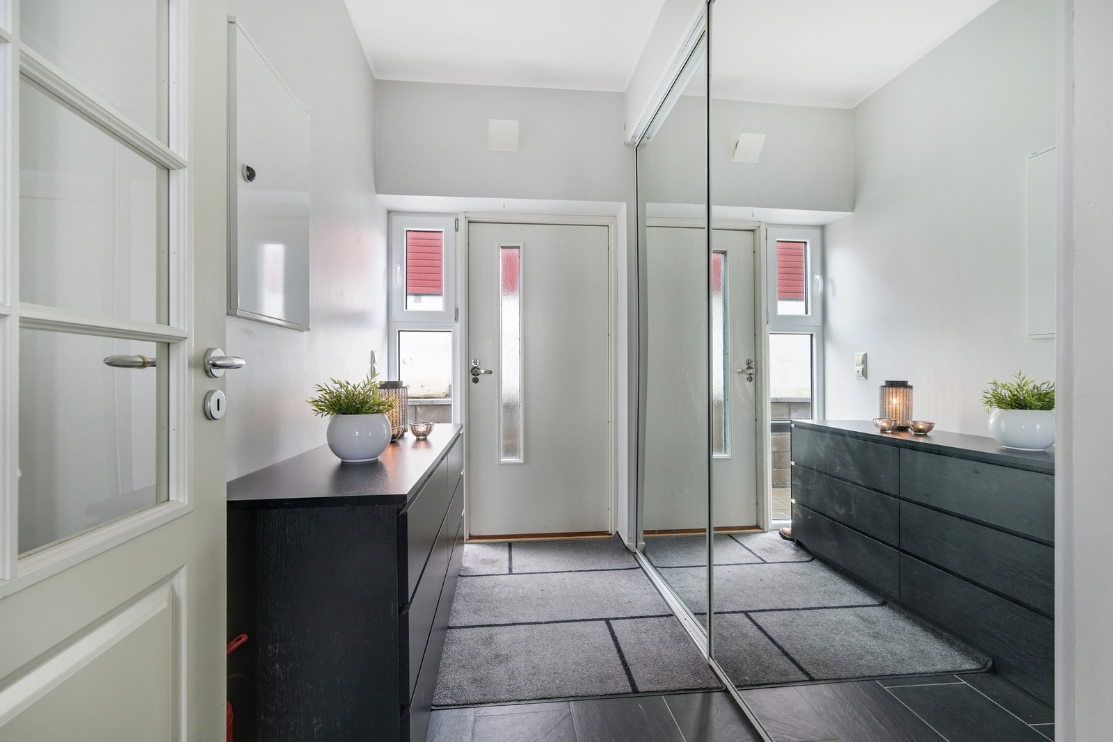 Egen inngang til flislagt vindfang med gulvvarme og stor skyvedørsgarderobe Galleribilde