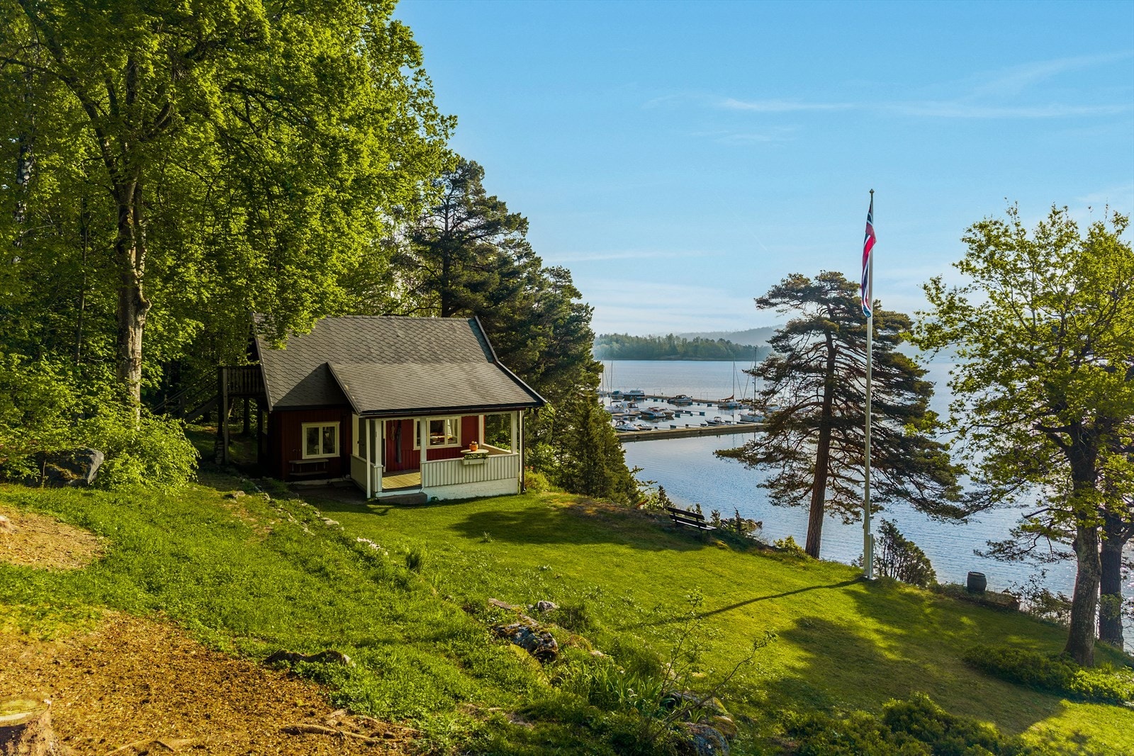 Tomten ligger for seg selv. Hagen har gressplen, variert beplantning og flaggstang. Galleribilde