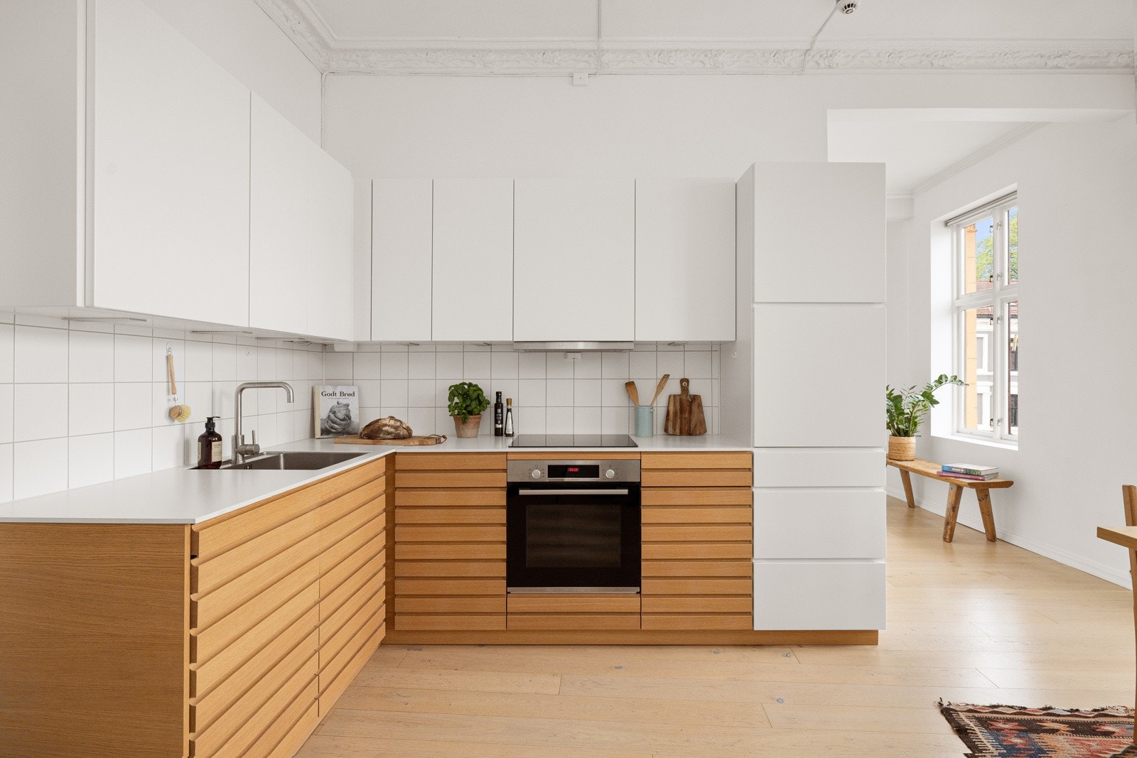 Praktisk med fliser i benkeryggen og belysning under overskapene. Medfølgende integrerte hvitevarer som stekeovn, nedfelt induksjonstopp, oppvaskmaskin og kjøleskap med frysedel. Galleribilde