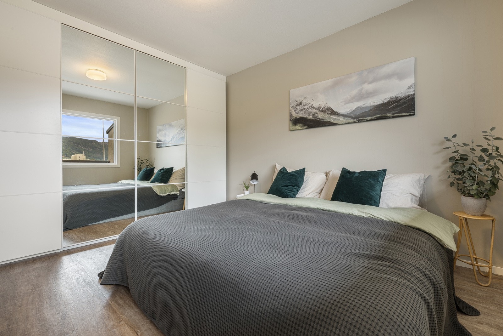 Hele den ene veggen er dekket med stor skyvedørsgarderobe som gir god oppbevaringsplass Galleribilde