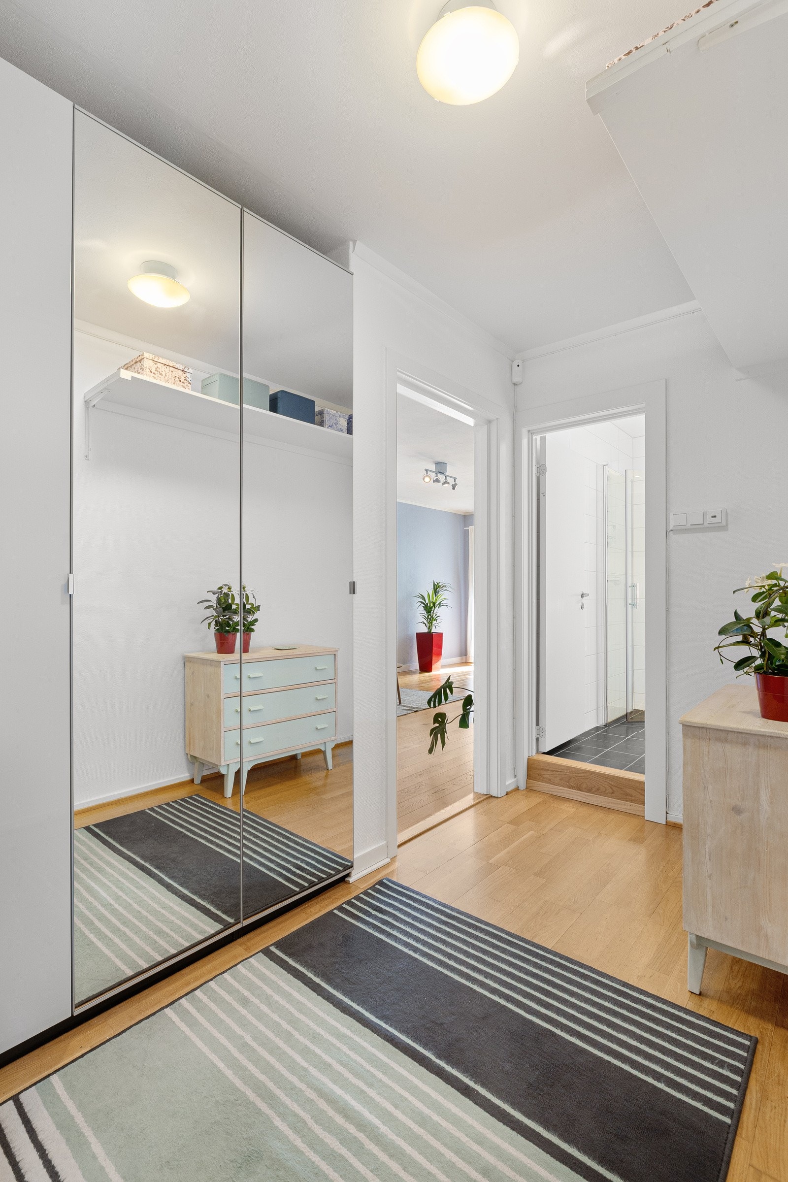 Gangen har parkett på gulv og skyvedørsgareobe med speilfronter fra 2018. Galleribilde