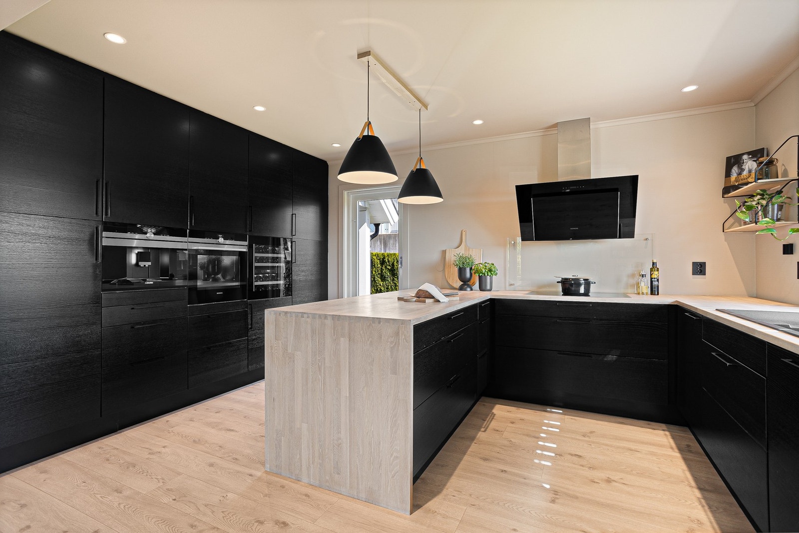 Innredningen fra Epoq har sorte, finerte fronter, takhøye skap og lyslasert heltrebenkeplate med grå oppvaskkum i kompositt. Galleribilde