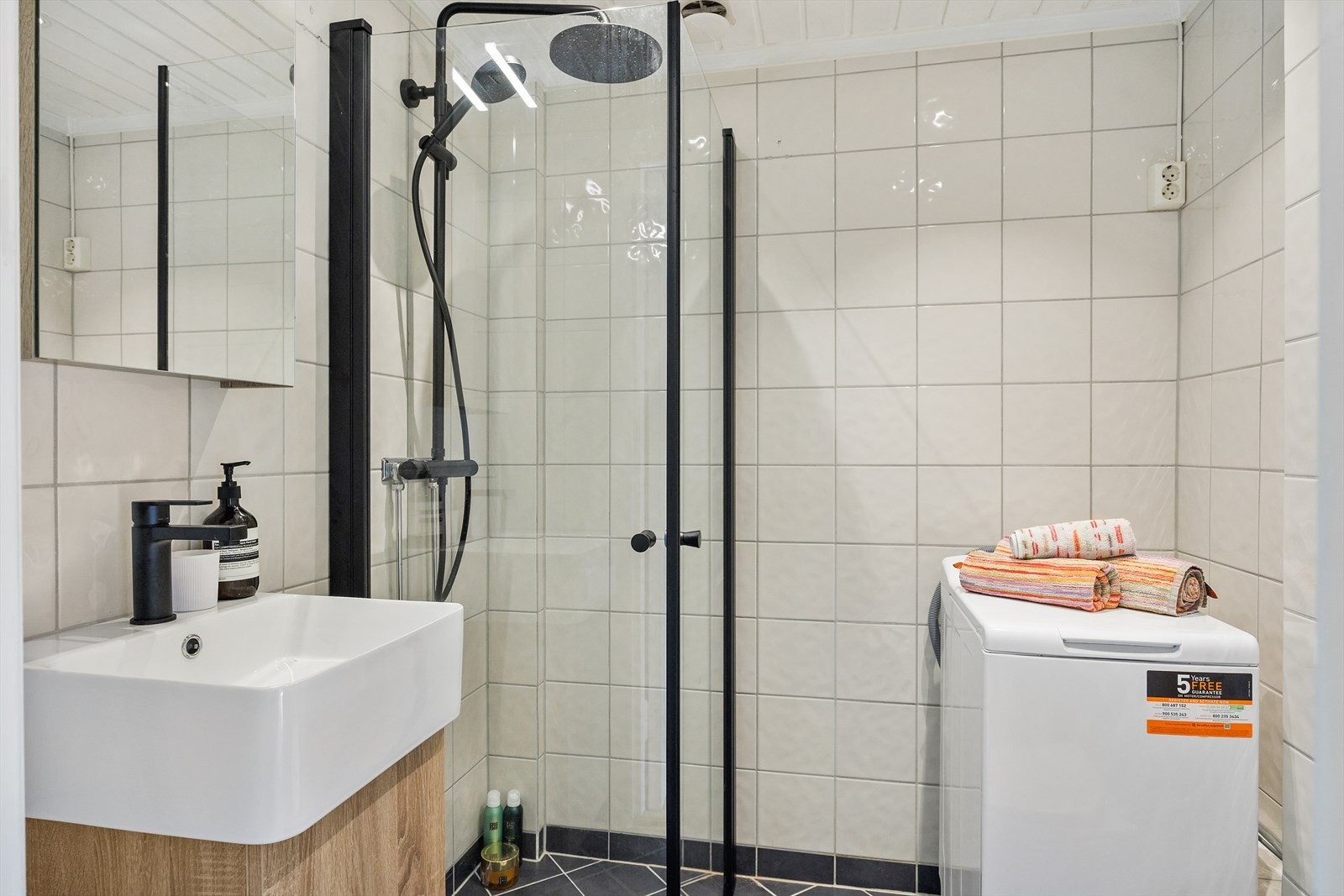 Baderommet er innredet med klosett, servant skap med glatte, folierte fronter, speil og dusjhjørne. Det er naturlig avtrekksventilasjon og opplegg for vaskemaskin. Galleribilde