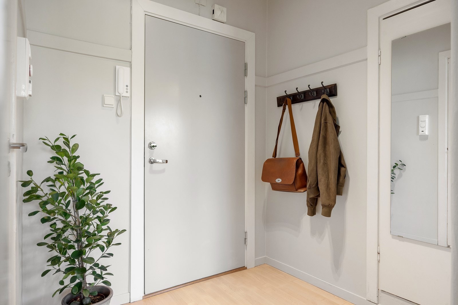 Leiligheten har en lys og innbydende entré som gir et godt førsteinntrykk. Her er det god plass til oppbevaring i et plassbygd garderobeskap med glatte, malte fronter. Galleribilde
