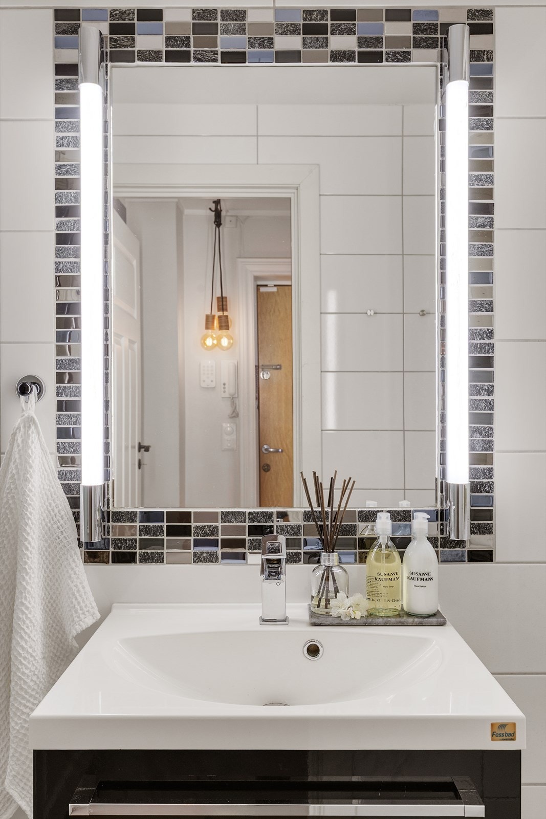 Badet er innredet med servantskap med heldekkende servant, armatur, speil og lys over servant, dusjhjørne med innfellbare glassdører tilkoblet hånd -og regndusj samt toalett. Galleribilde