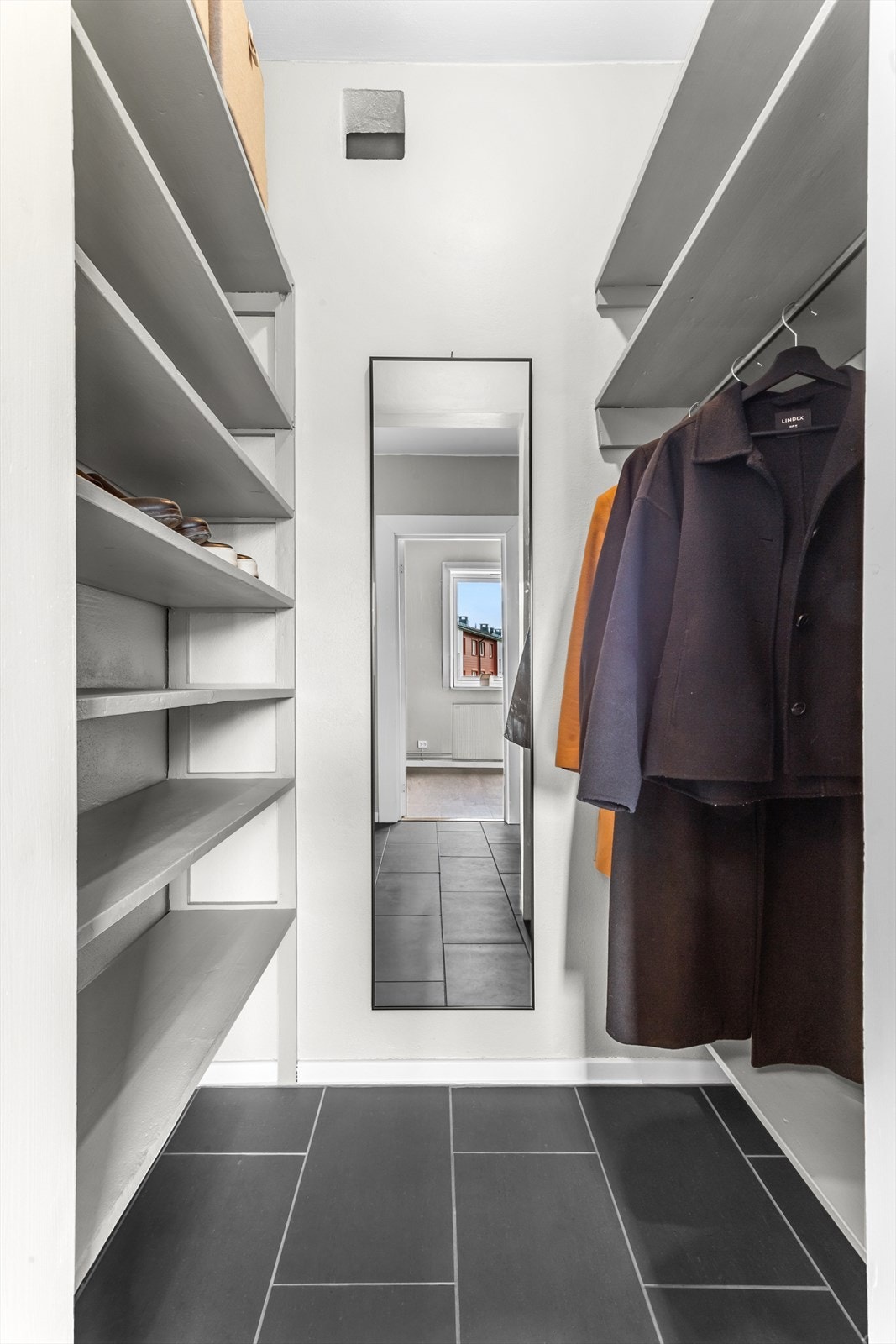 God plass til å henge av seg yttertøy i en praktisk garderobeløsning med plassbygde hyller. Galleribilde